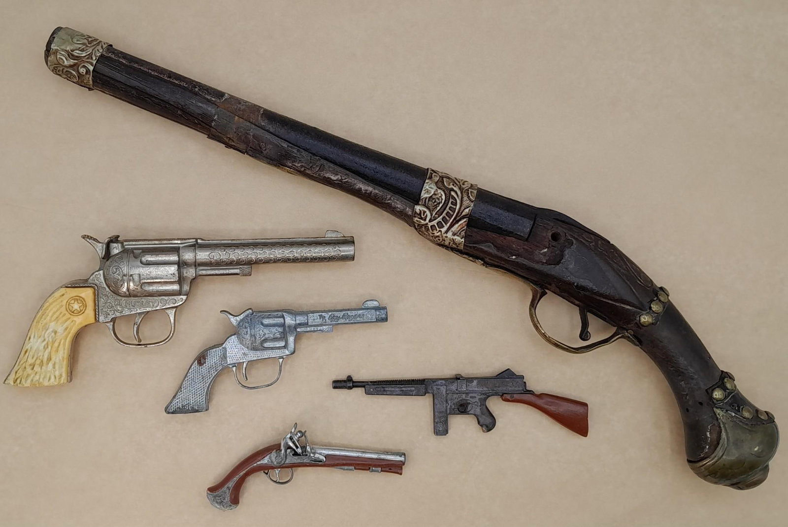 5 pc Hubley, Roy Rogers, Miniature Flintlock Pirate Cap Gun & Thomposon Machine Gun Toy Lot: 1) Mini 4 7/8" operational flintlock cap gun toy2) Spring action mini Thompson submachine toy, 6"3) Hubley operational wild west cap gun revolver toy, 8 1/2"4) Mini 5 3/8" Roy Rogers f