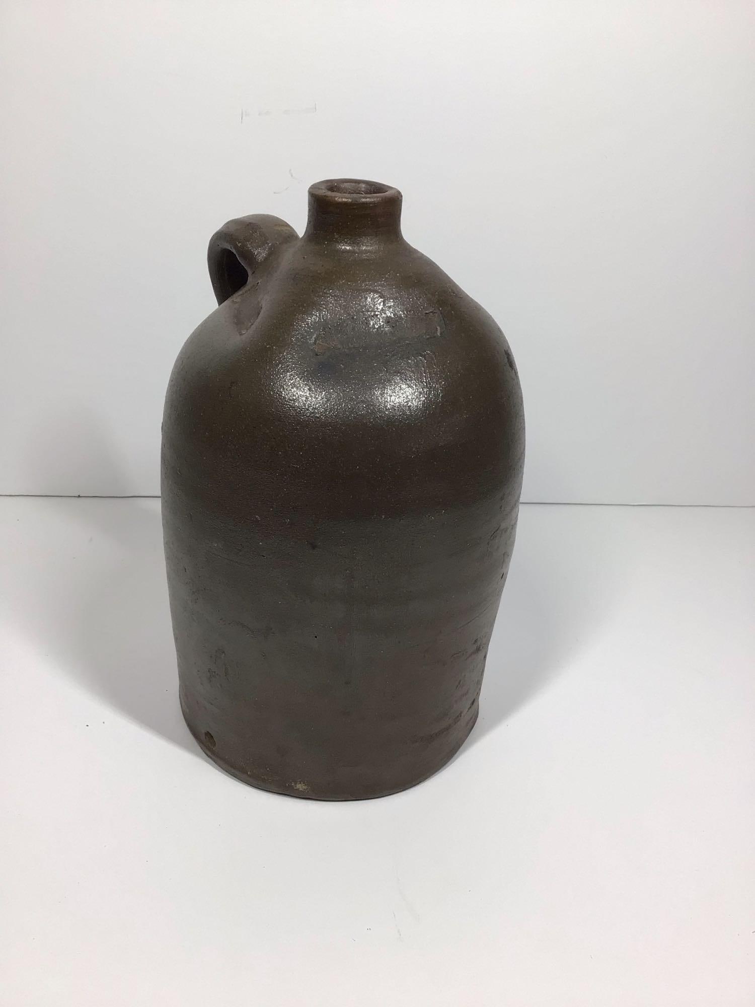 Early 1-gal stoneware jug: Does have a factory made hole on side just above base for dispenser spout and with clamp marks on shoulder. Also has a small chip on top of handle and rim otherwise is good.