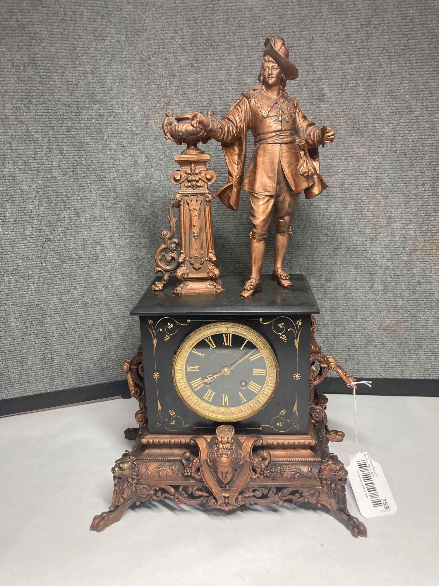Jules Wendell & Sons Musketeer Sculptural Clock: Heavy cast body with lions heads, goddess faces, pedestal urn and ornate detailing. No key. 19x12x7.