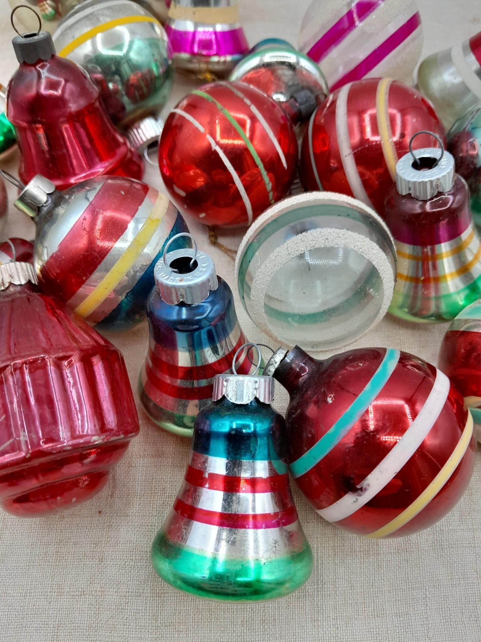 24 Vintage Shiny Brite Mercury Glass Bell & Ball Ornaments: Most marked Shiny Brite USA, others marked Made in USA, a few replaced caps, 2 Shiny Brite boxes included, cellophane window damaged as shown, varied age and wear, structurally sound.