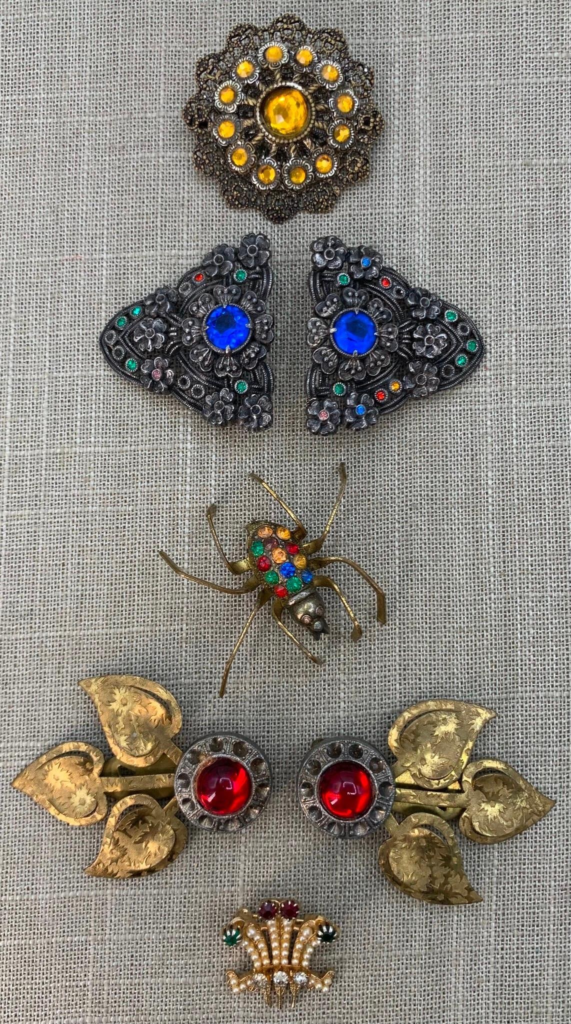 7 pc 1930s to 1940s Art Deco Fur Clips, Jeweled Sash Buckle, Pins & Sparkling Spider Brooch: 2 1/2" x 1" in size, some missing stones as shown, working closures, colorful stones set in early pieces.