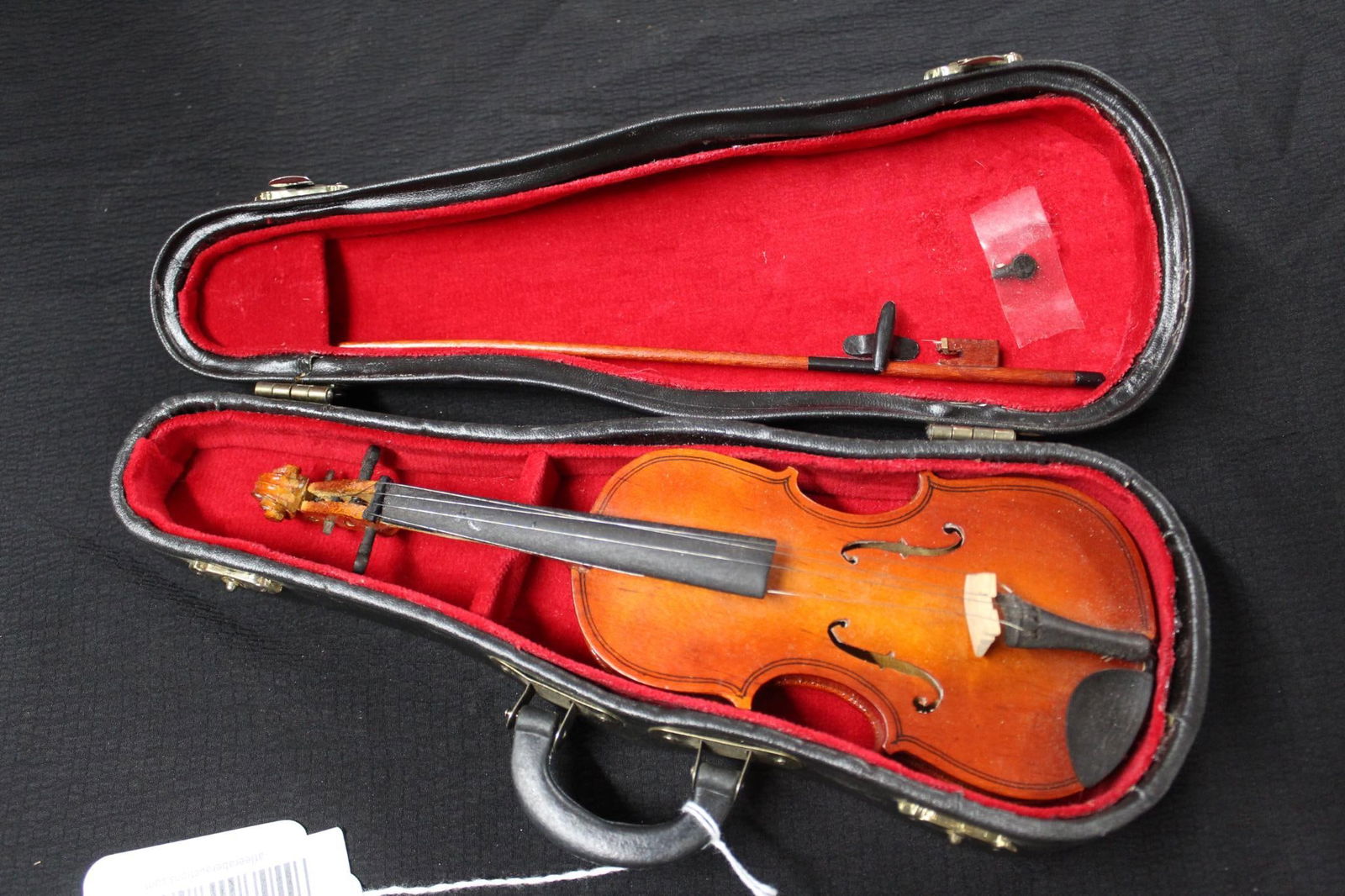 MINIATURE CELLO: INCLUDES A BOW AND FELT LINED CASE. BOW IS MISSING STRING AND WINDING KEYS ON INSTRUMENT ARE MISSING/ OR HAVE DAMAGE. 9 INCHES LONG