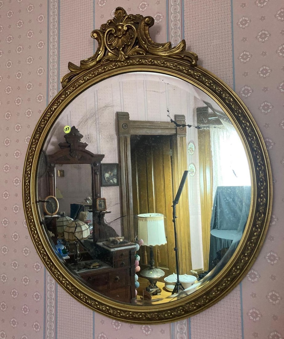 Gilted round wall mirror: beveled older glass and ornate frame. 24 inches round