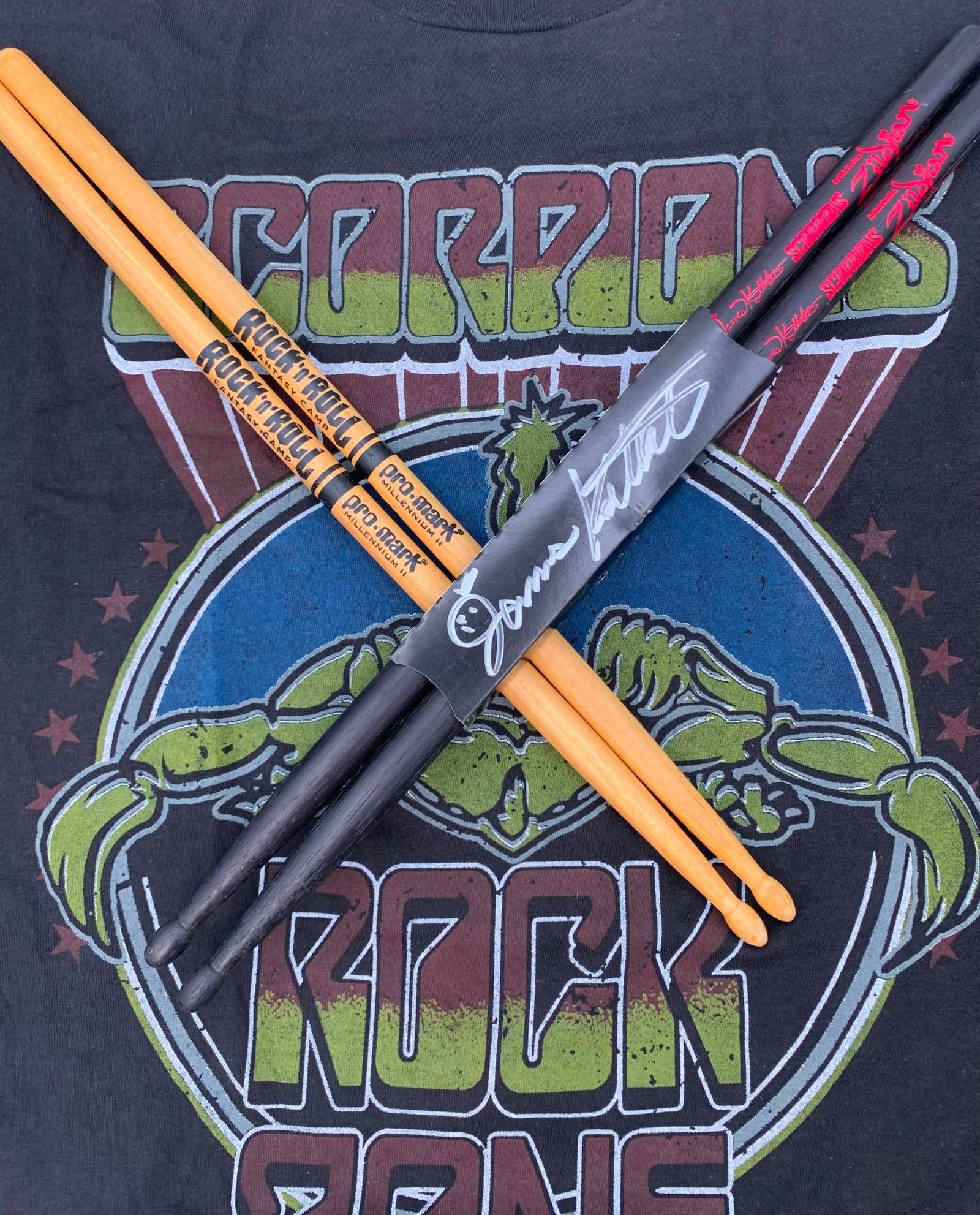 SCORPIONS Rock Band Drummer James Kottak Autographed Drumsticks & Rock Zone Concert T-Shirt: Kottak was fired from the band in 2016, he died Jan 9 2024. Clear signature, offered with the Scorpions logo Zildjian sticks, a pair of Rock-n-Roll Fantasy Camp hickory sticks and the Tultex 