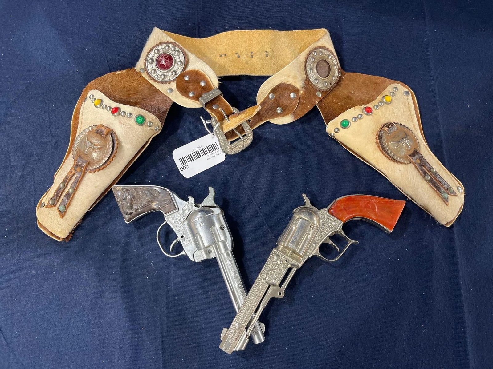 Roy Rogers & Hubley Cap Guns in Leather Holster: 1950s calf hair holster w beaded studs. Medallions on holsters show some spotting.