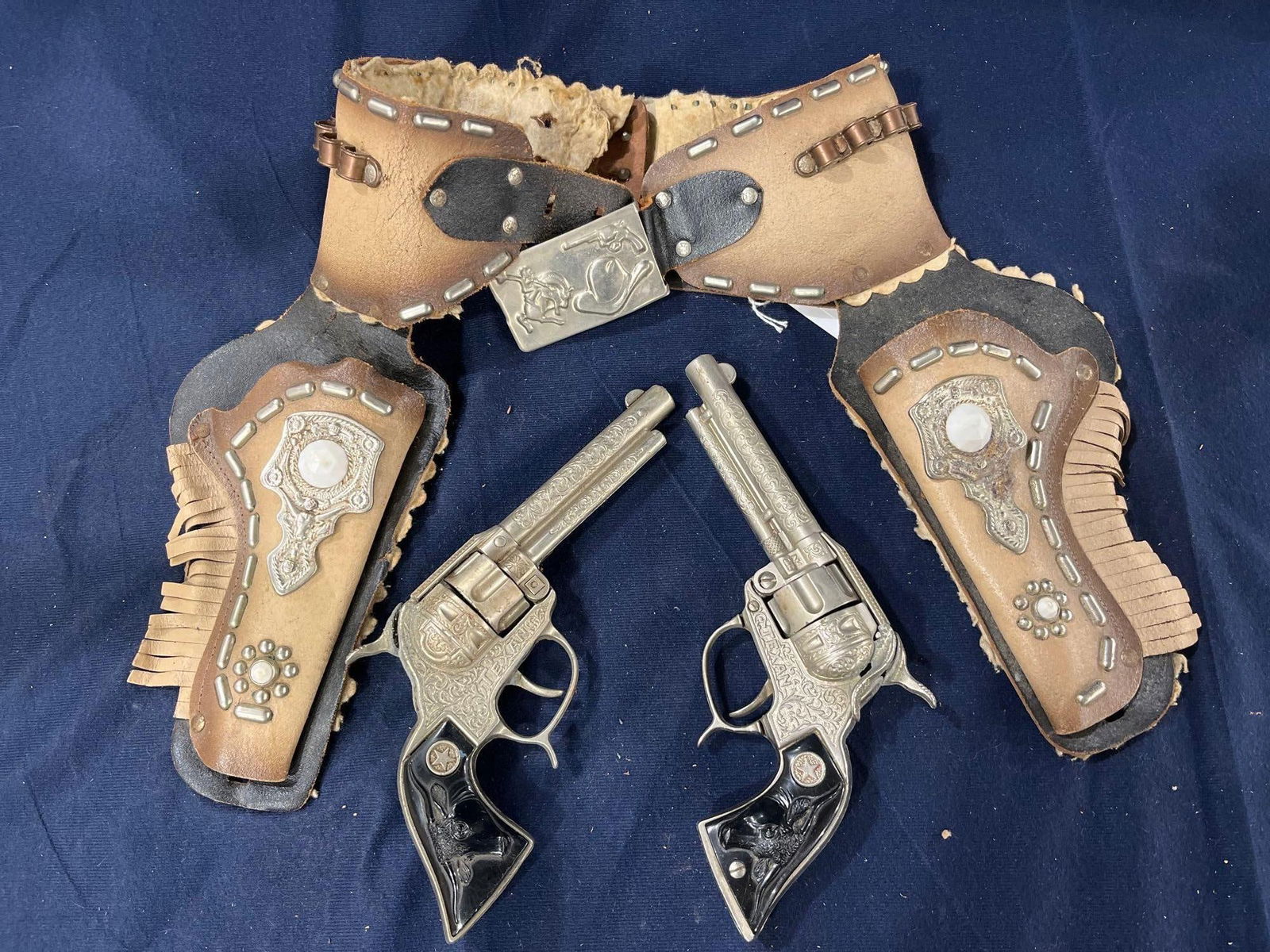 1950s Hubley Texan Cap Guns: Ombre leather holster & faceted Gem detail. Minor surface spotting to metal surfaces of holster.