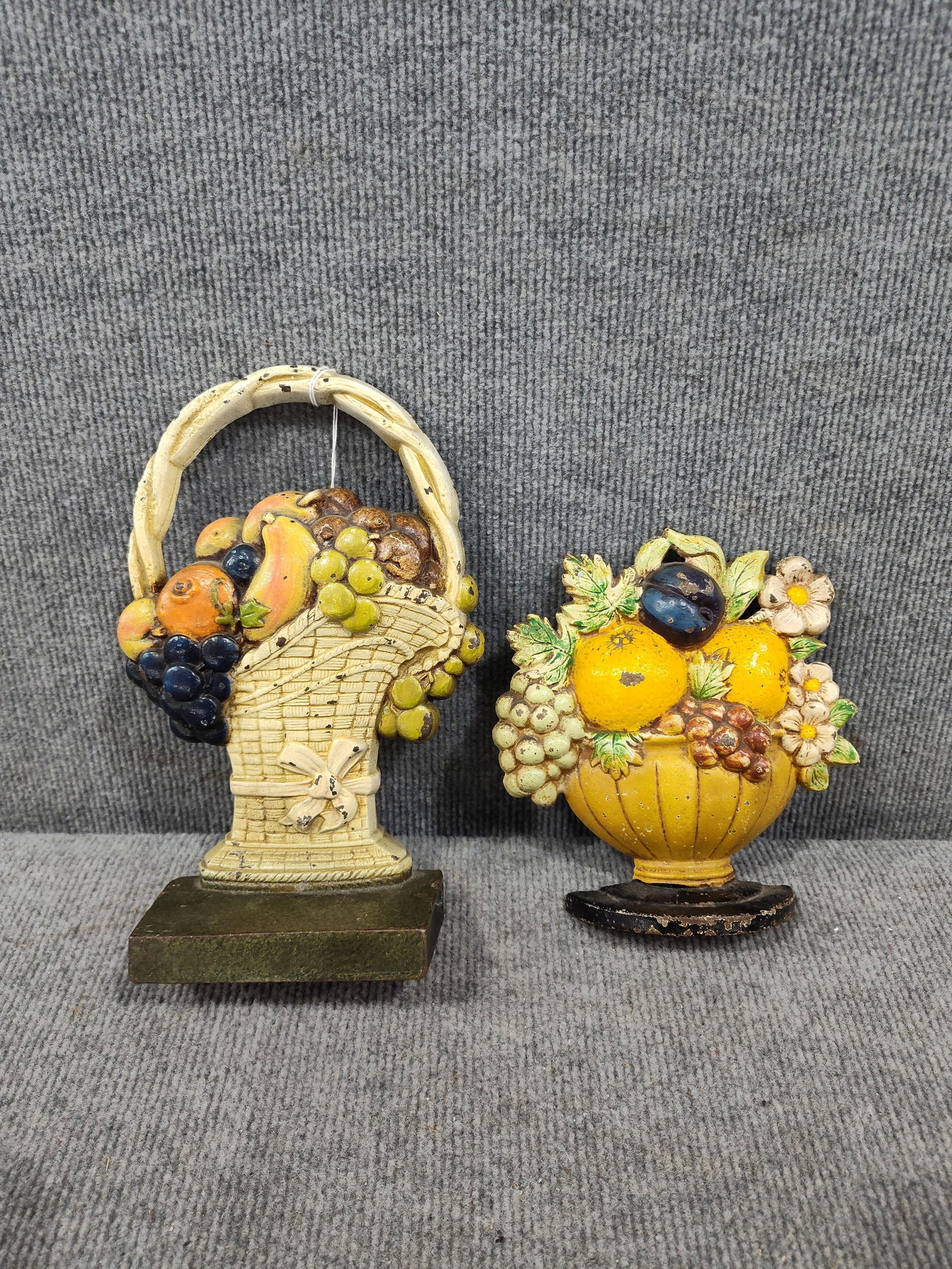 Cast Iron Fruit Basket Door Stops: Both early pieces are painted and free of any heavy rusting or damage. 7 and 9.5 inches tall. One is Hubley