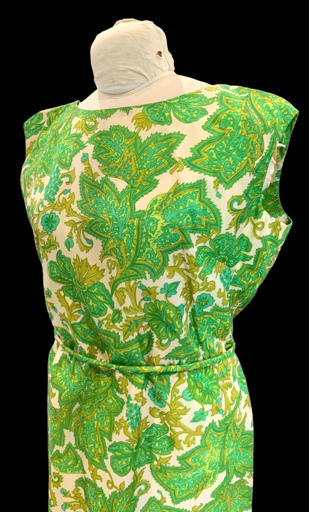 1960's McInerny Polynesian Casual Hawaiian, Honolulu, Belted Ladies Dress: Generously sized with self fabric belt and plastic zipper, lined in sheer cotton with ruched and slit shoulder, toggle detail at the rear with low cut back and walking slit. Measuring approximately as