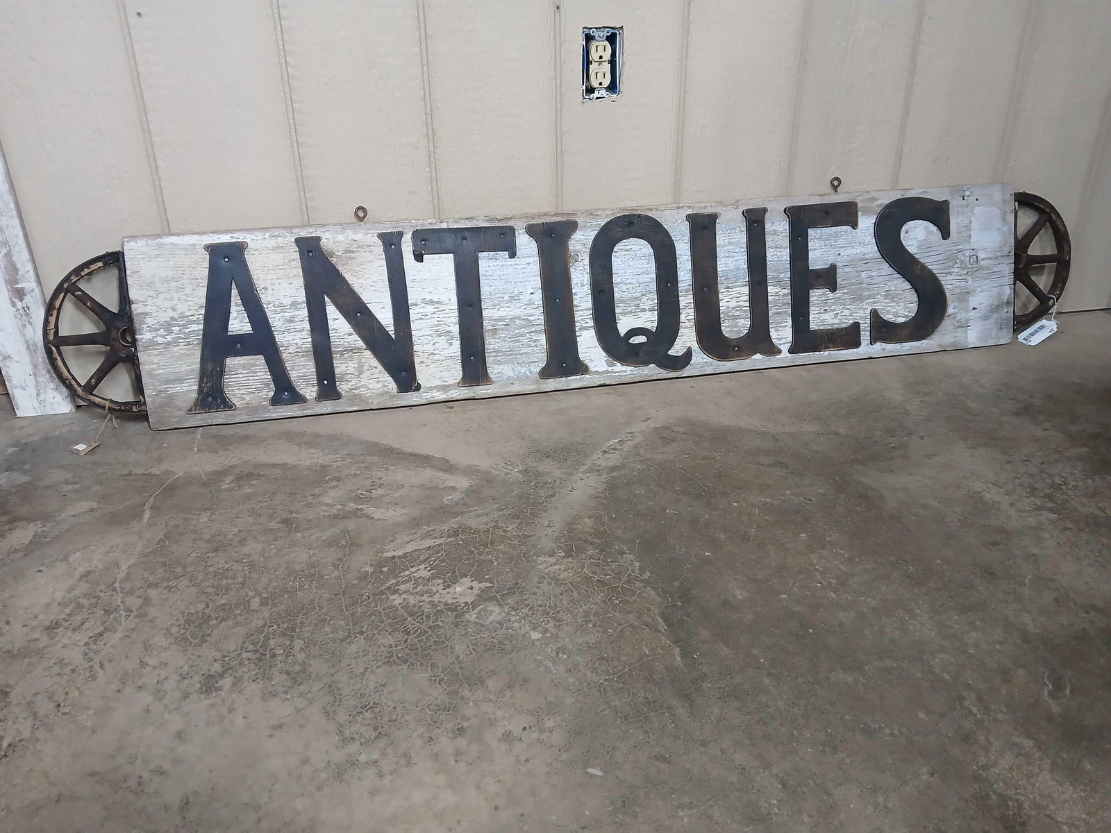 Folk Art wooden ANTIQUES sign: 1-sided wooden sign with half wheels on the ends. 11.5in x 69.5in.