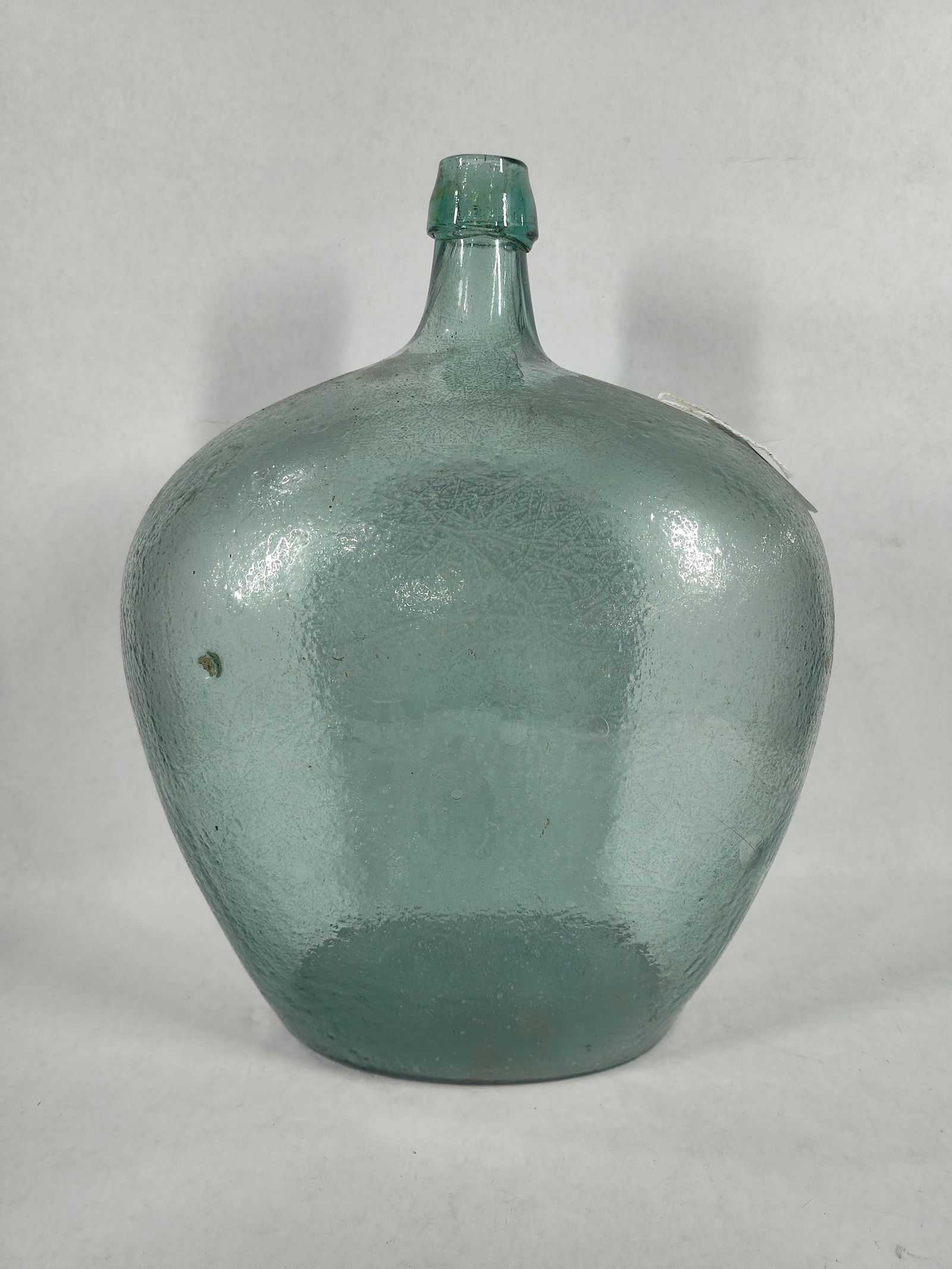 French Demijohn Glass Bottle: A Lighter blue glass with blob top. 17x12x7, no cracks or large chips.