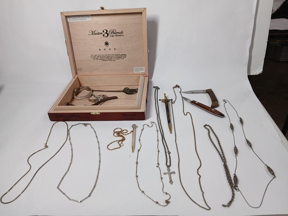 Sword Daggers, Wrist Watches, Pocket Knives, and Jewelry: A wide variety in this lot including a mechanical pencil, Rosaries, several necklaces, watches and more. All come in a wooden Liga Maestra Cigar box