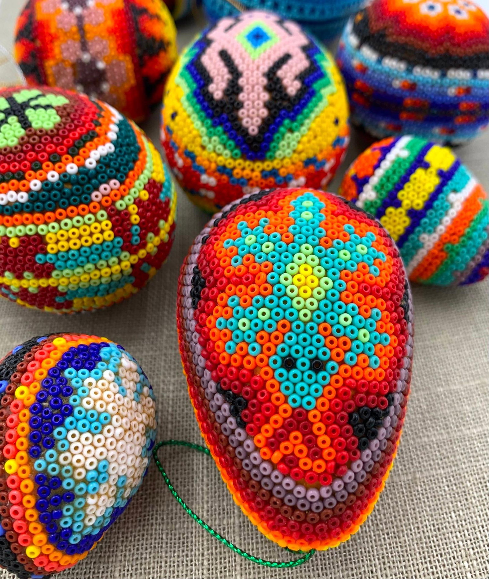 10 Vibrant Vintage Mexican Huichol Beaded Ornaments: Intricately patterned beadwork covers each ornament, from 1 3/4" to 2 7/8", hanging cord present on each.