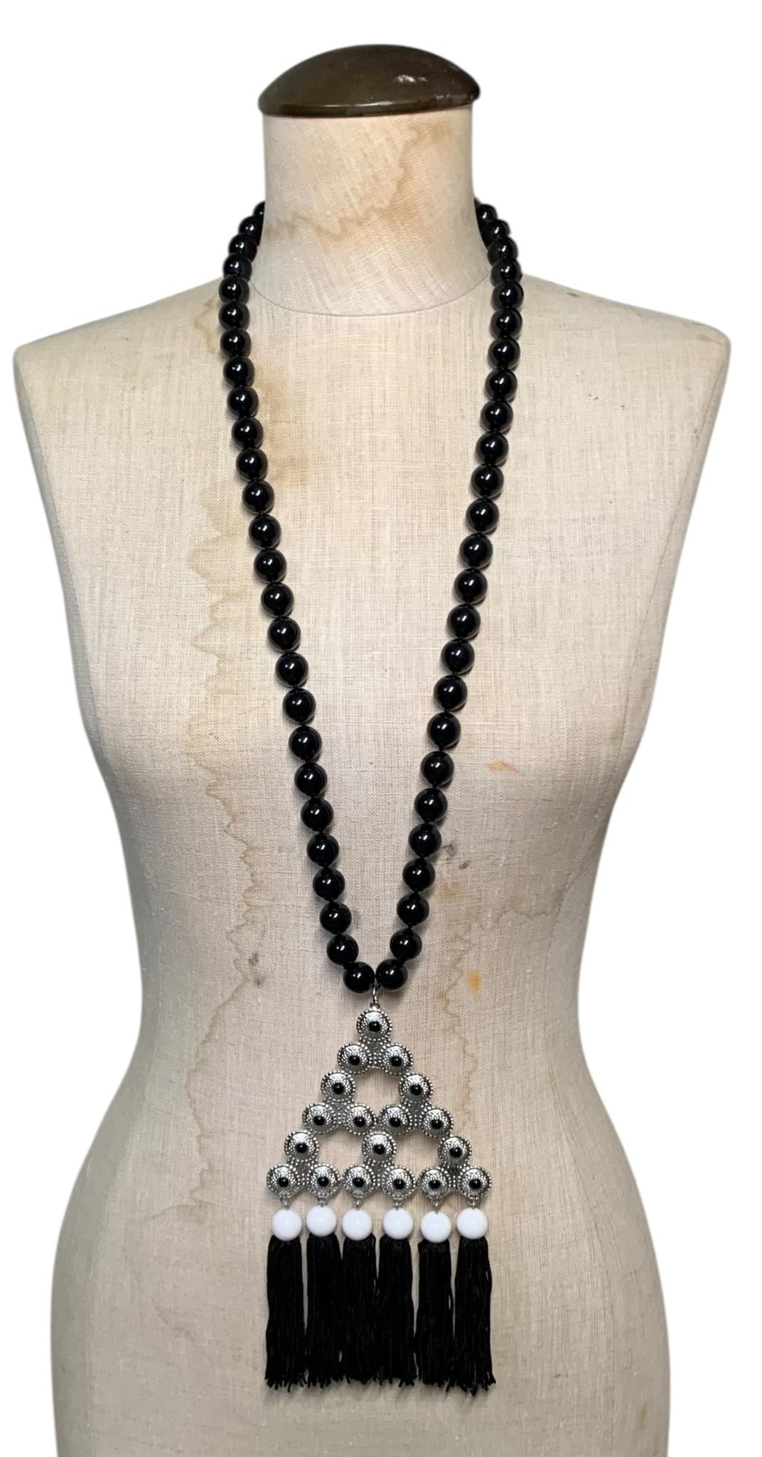 Late 60s Bill Smith of RICHELIEU Dramatic Fringed and Beaded Silver Amulet Body Jewelry Necklace: Iconic Bill Smith design with large black and white beads, raven fringe and embossed silver metal black pyramidal amulet, hand knotted, 24" x 4", paired with a oversize pair of vintage 1 5/8" white co