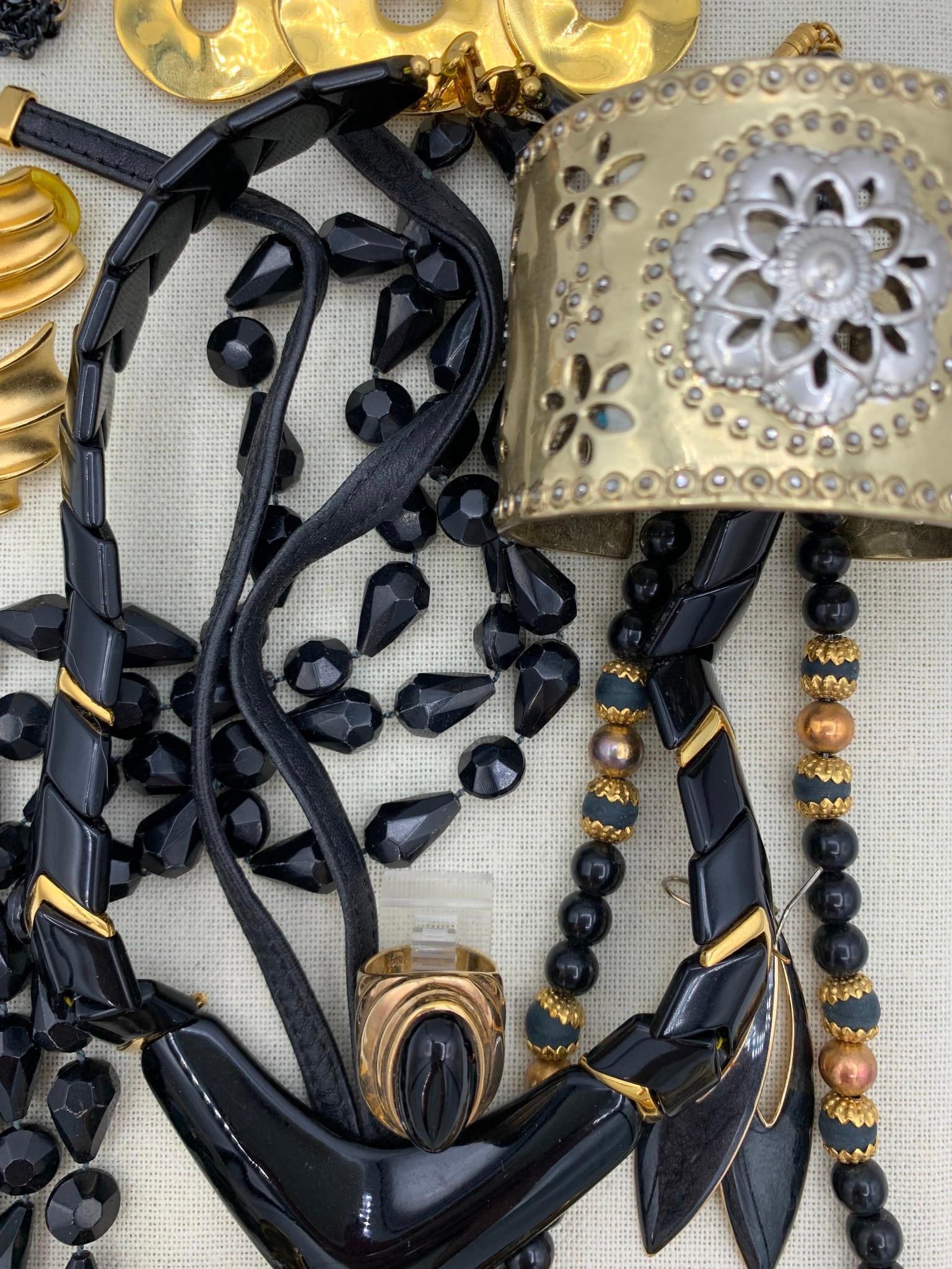 22 pc Napier, Trifari, 1928, Lucky, 1960s - Modern Raven and Gold Black Costume Jewelry Collection: Fab assortment of baubles with working closures, some distortion to the cord foundation on the Napier black and gold arrow link necklace, paper label inside of the Lucky cuff, a few missing earring ba