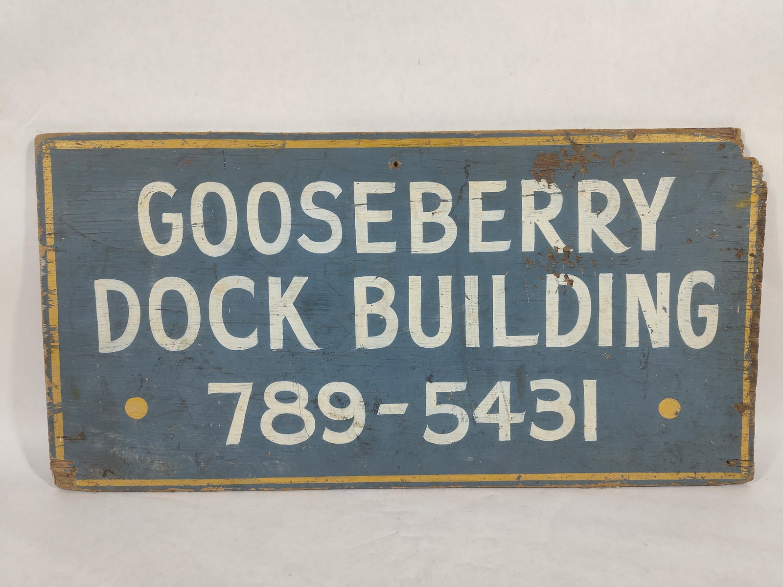 Gooseberry Dock Building Stenciled Sign: Robin egg blue paint. 20 x 10. Two corners show chipping