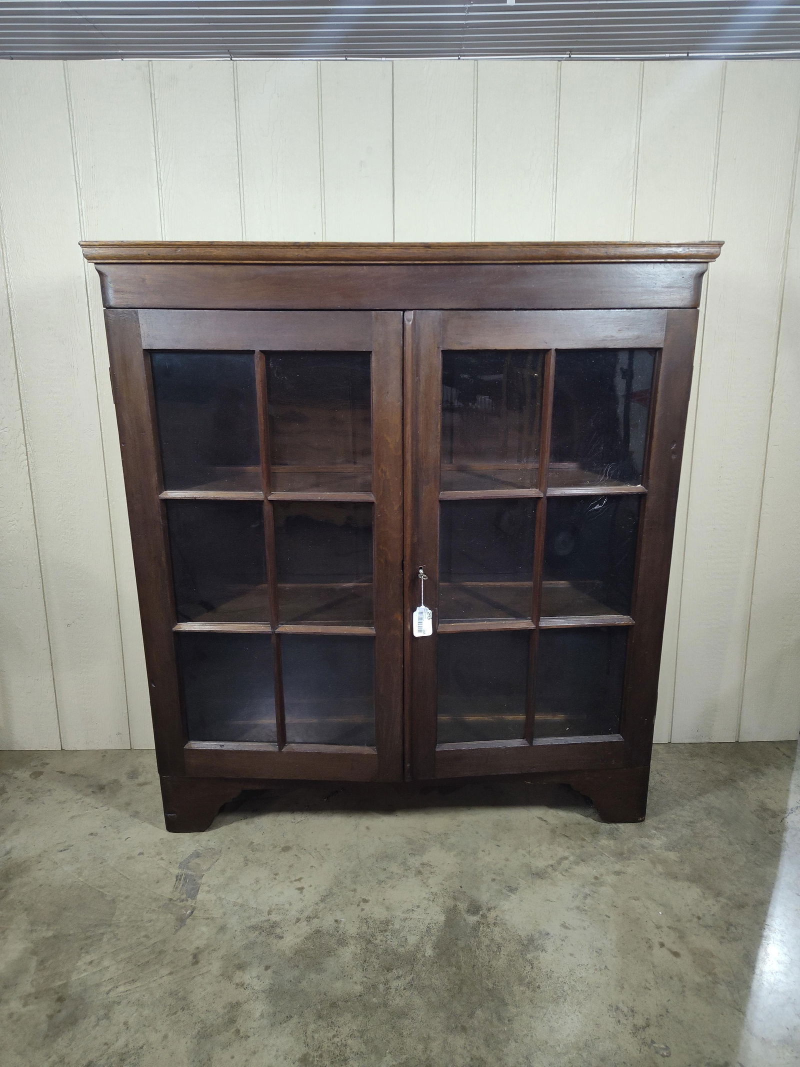 Walnut 2 Door Cabinet: Each door featuring 4 glass panes. and interior shelves. Appear to have a later trim added around top. Good solid condition. 54x49.5x15