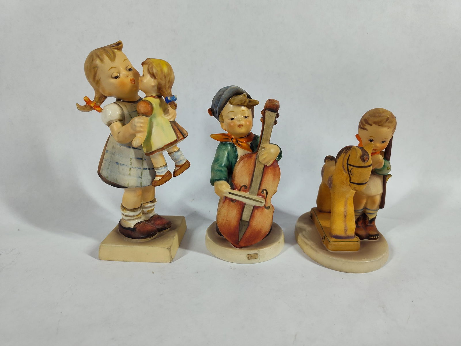 Goebel Hummel Figurines: Sweet music #83, Prayer Before Battle #20, and Kiss Me #311. All in good condition made in West Germany