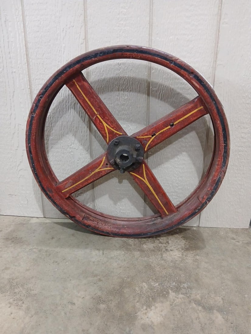 Folk Art Painted Wooden Wheel: Nice red paint with yellow and black striping. Iron center hub with wooden spokes. 26 inches in diameter