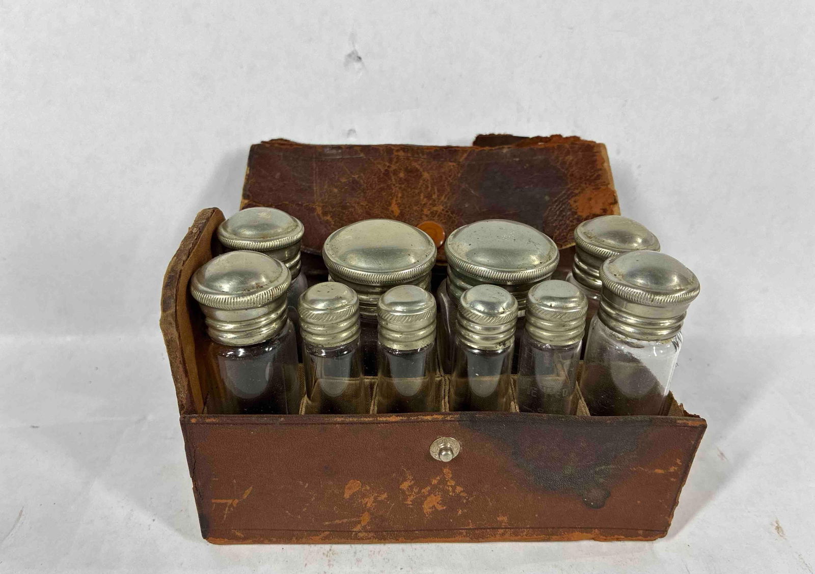 Early Traveling Doctors Apothecary Bottles: 10 glass bottles, several are marked C&E to bottom. Comes in leather covered case. Bottles range from .5 inches to 1.5 inches in diameter and are 4 inches tall.