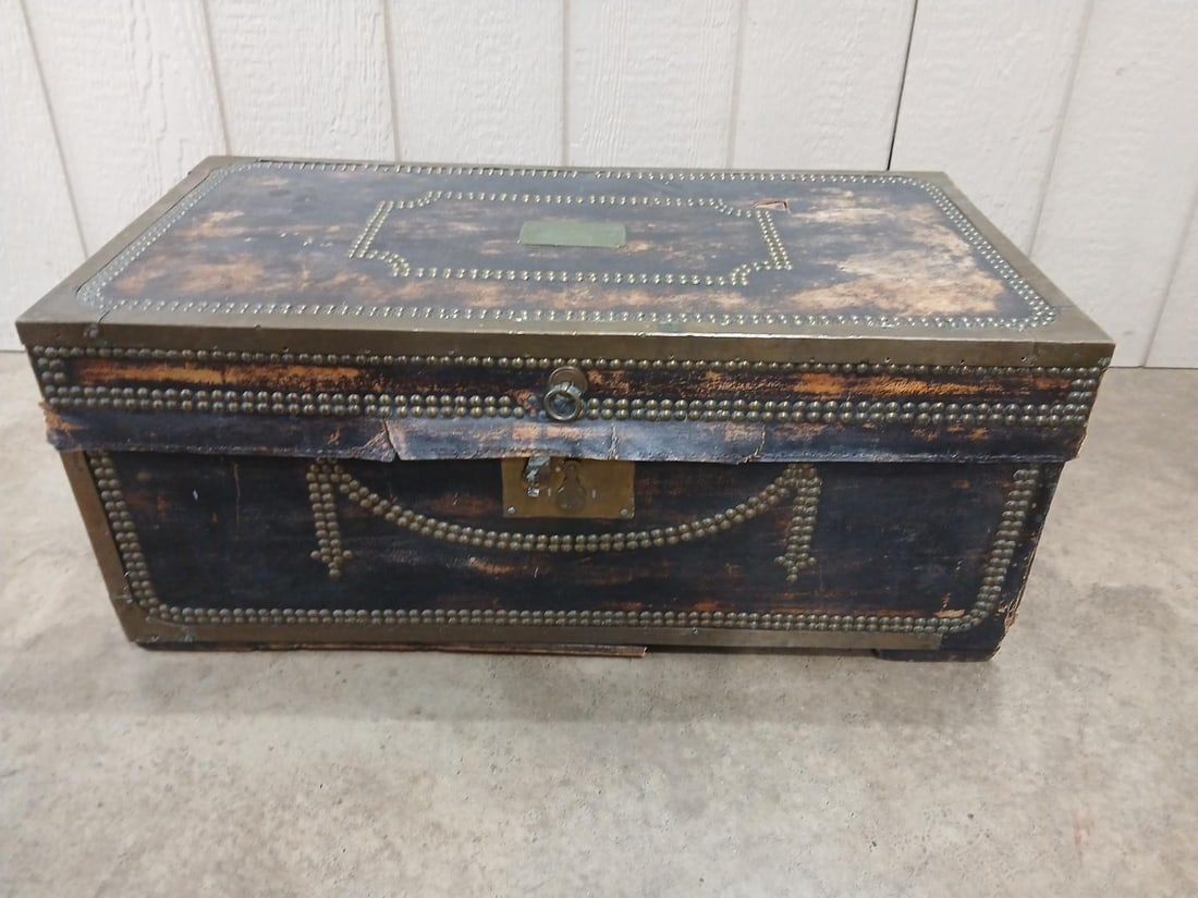 Leather & Brass Travel Trunk: Eagle Detail to closure. Brass tag on top reads Clement Littlefield. Leather shows some age and holes in small areas. brass rivets and trim line this wooden bodied trunk. 30x15.5x13