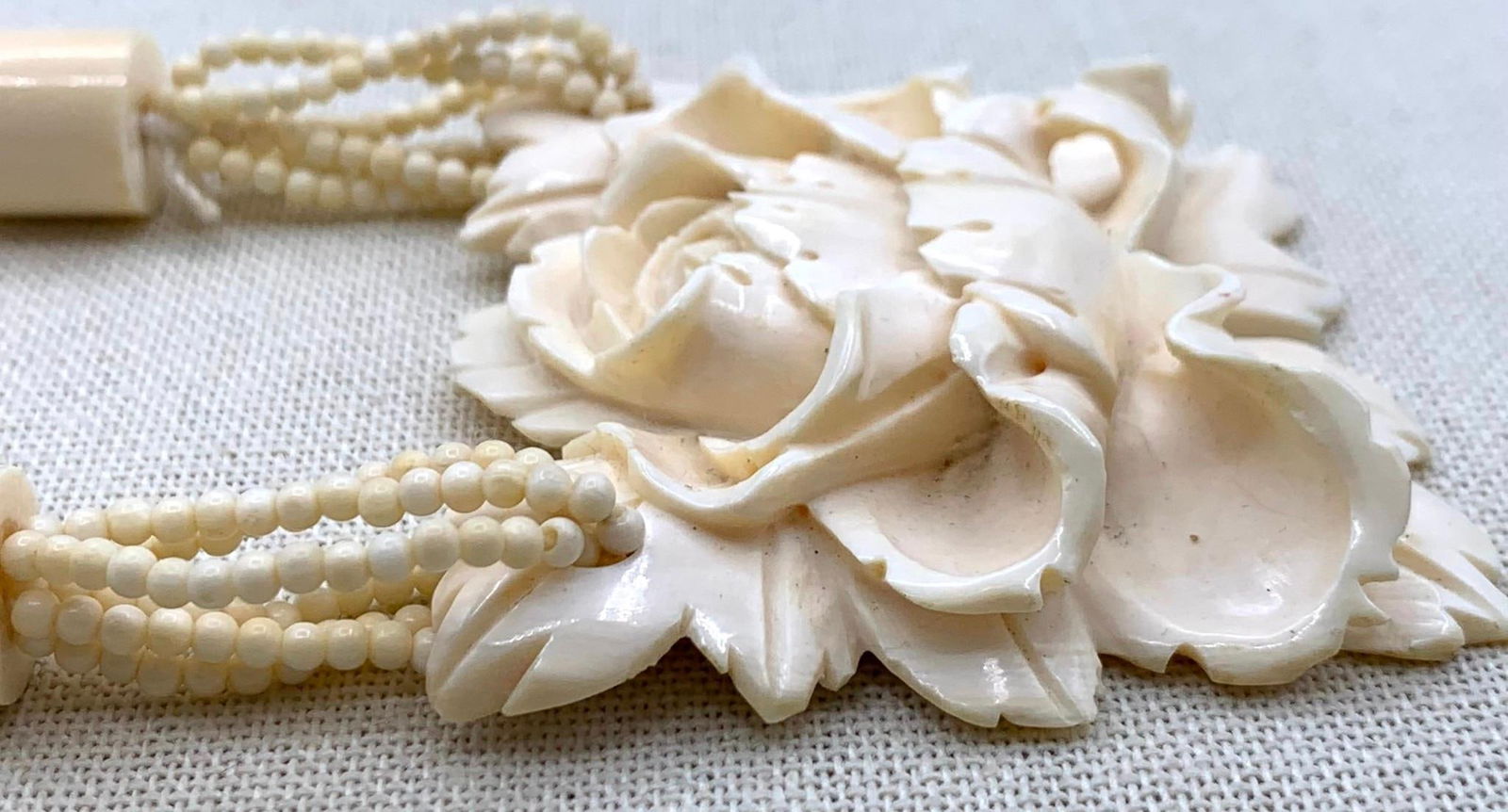 Superb Hand Carved Natural Material Large Floral Pendant and Petite Bead Necklace: 2 5/8" x 2 1/4" blossom, 14" neck circumference, working barrel closure.