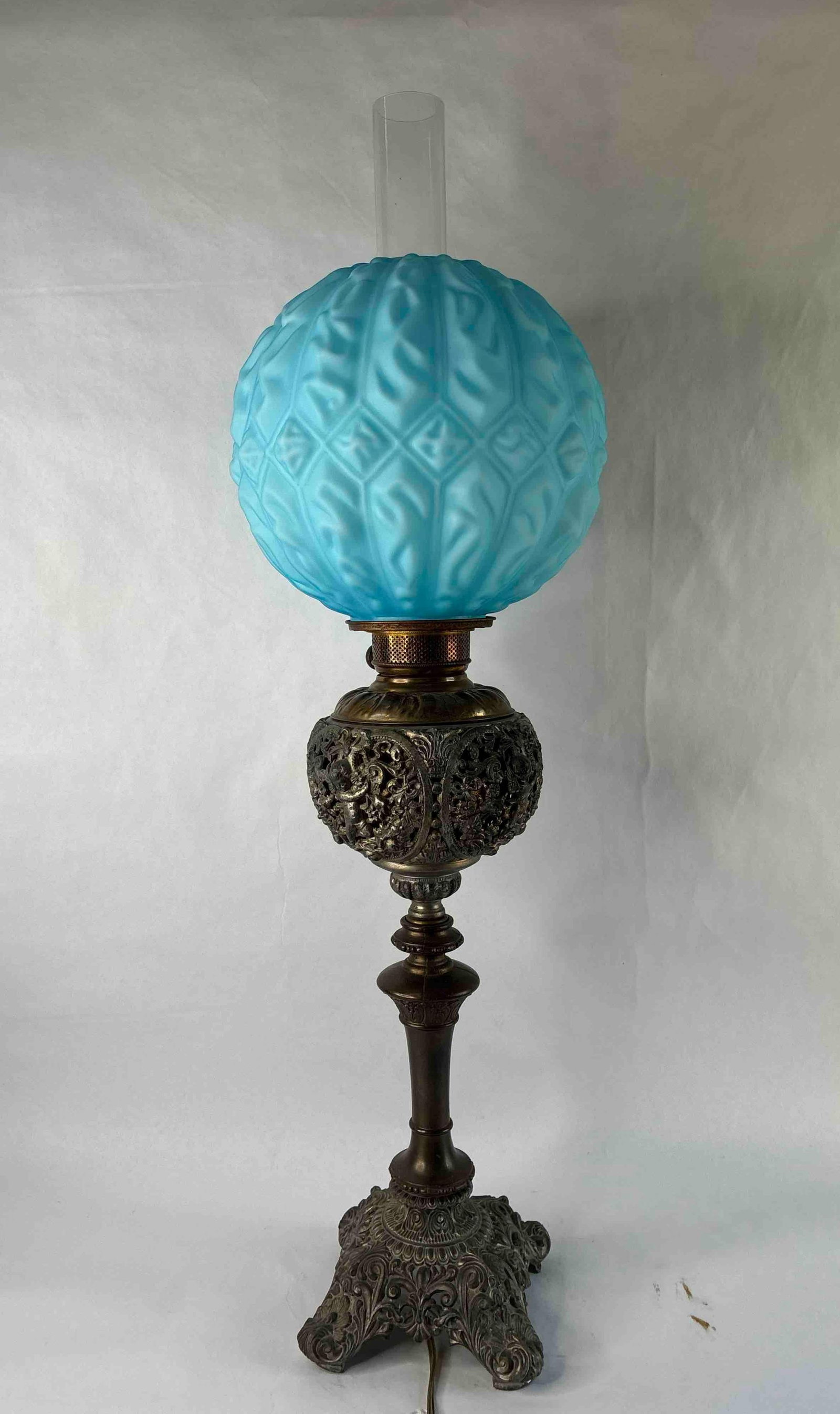Early 1900s Cherub Spelter Parlor Banquet Lamp: Satin blue glass globe. Base features cherubs and floral openwork. 36 inches tall. Keroscene lamp has been converted to electric. 