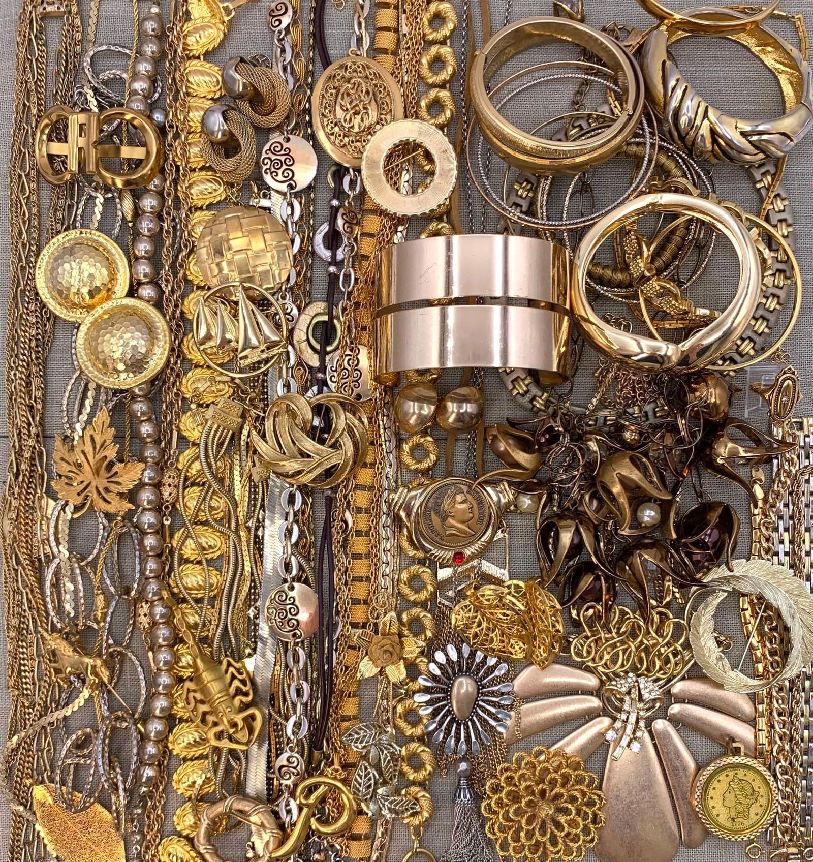 80 pc Gleaming Golden Costume Jewelry Collection: Bangles, Cuffs, Brooches, Necklaces, Earrings and Pendants galore, all in gleaming golden metal.