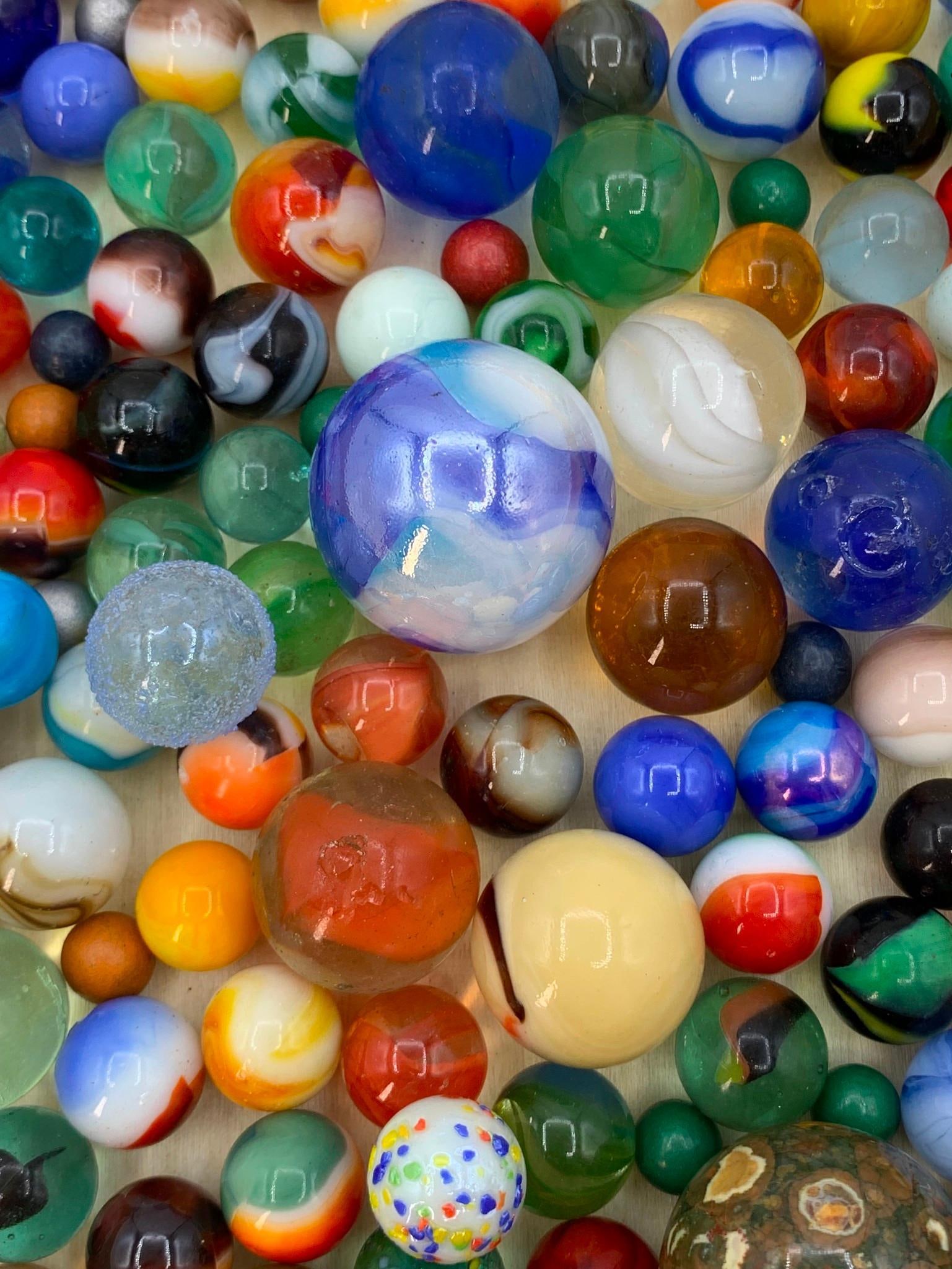 2 3/4 POUNDS Vintage Marbles, Shooters and Natural Stone Spheres: Art Glass, iridescent, cats eye, swirled, speckled, milk glass, 33mm to 9mm, some with age and wear.
