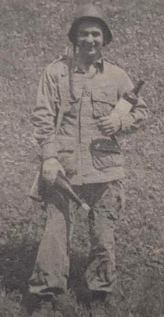 Hitler's Hideout Cognac Photograph: WWII Army Corporal Joseph Karasevic US Soldier Wartime Ephemera: WWII US Army Corporal who participated in the Normandy, Rhineland, Ardennes and Central Europe campaigns... including a photo of him wearing a German helmet and holding two bottles with a note on the