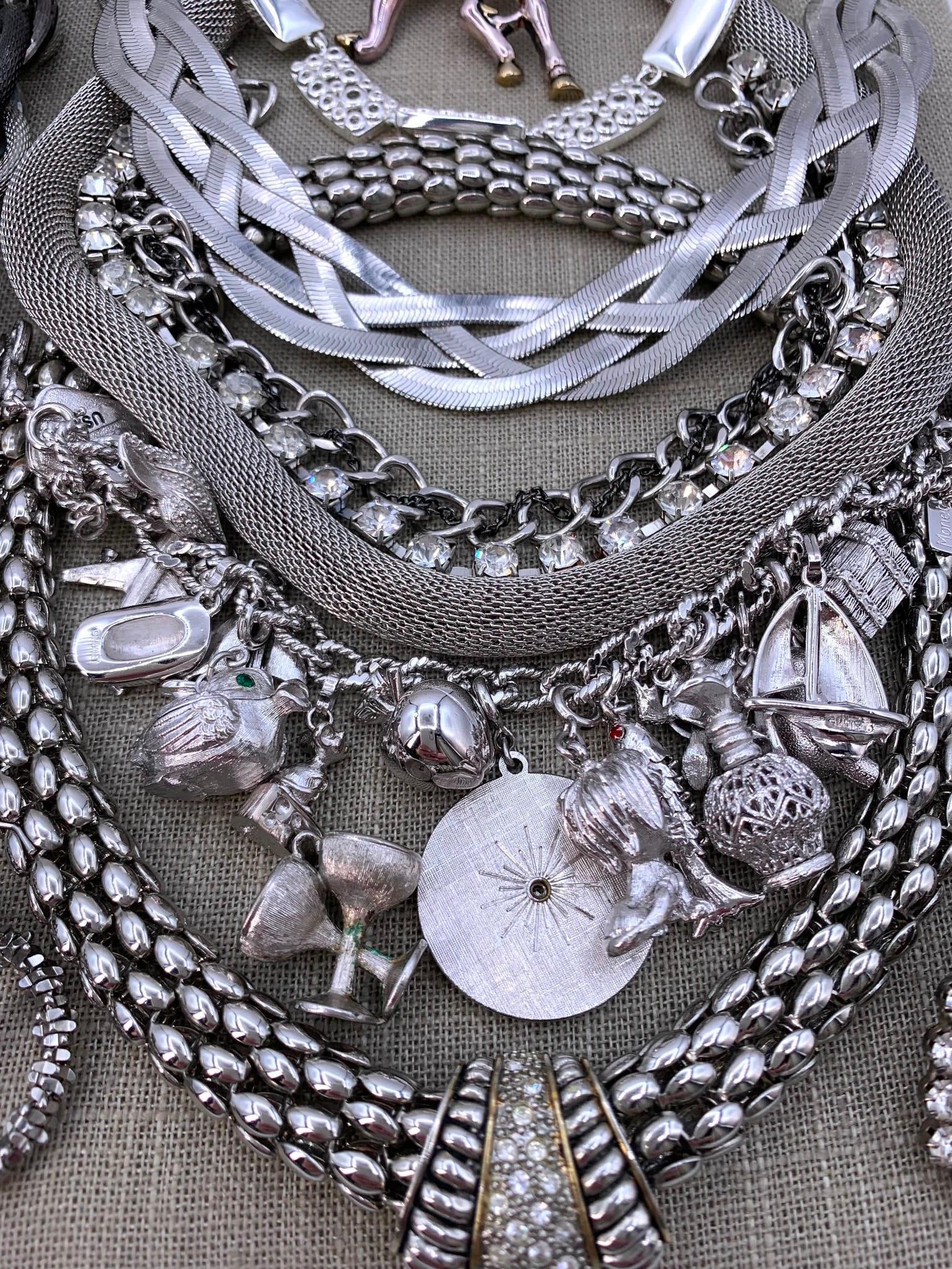 45 pc Gleaming Silver Costume Jewlery Monet Mechanical Charm Bracelet Collection: Fab variety of adornments, including a loaded Monet charm bracelet with oodles of articulated and mechanical charms, glittering rhinestones, statement necklaces, pierced and clip earrings, bangles and