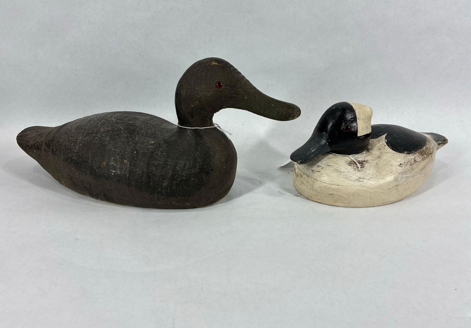 Pair of wooden carved Duck Decoys: Both with glass eyes and white one is marked RS on bottom.