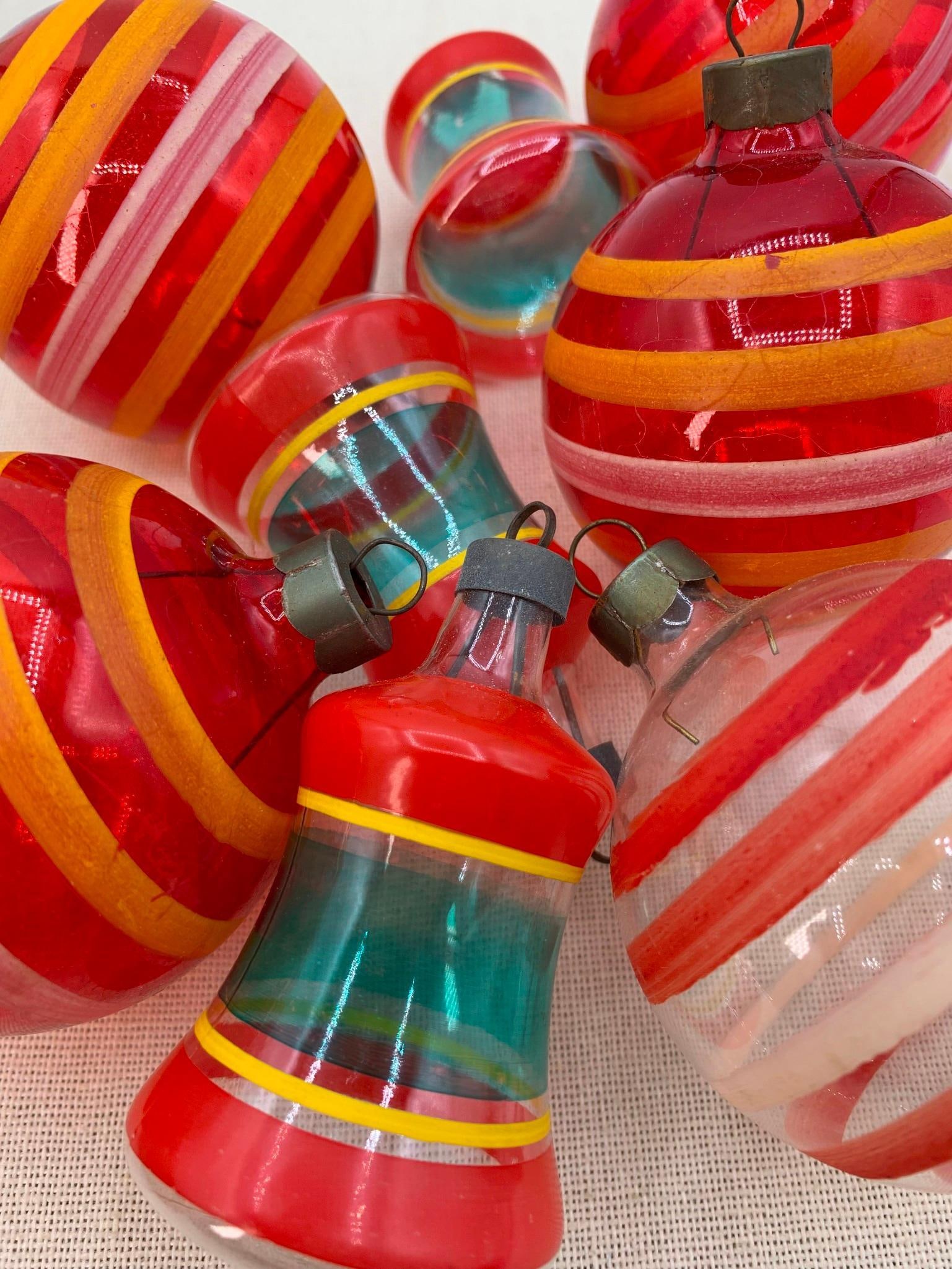 24 Mid Century Ruby Red Glass Bell & Orb Christmas Ornaments in Early Shiny Brite Boxes: Set of 12 2 5/8" ruby red glass USA bulbs, 4 ruby glass striped, 1 clear striped, 3 striped glass bells and 4 2 1/4" claret mercury glass, shelf wear and some age to the early Shiny Brite paperboard b