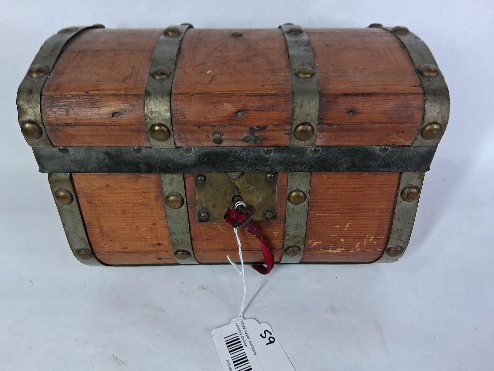 Mini Jenny Lind Domed Trunk: Interior is lined with an older pattern paper and window has been made to inside of lid. Missing one brass embellishment button. Locking key is included. 10x7x7