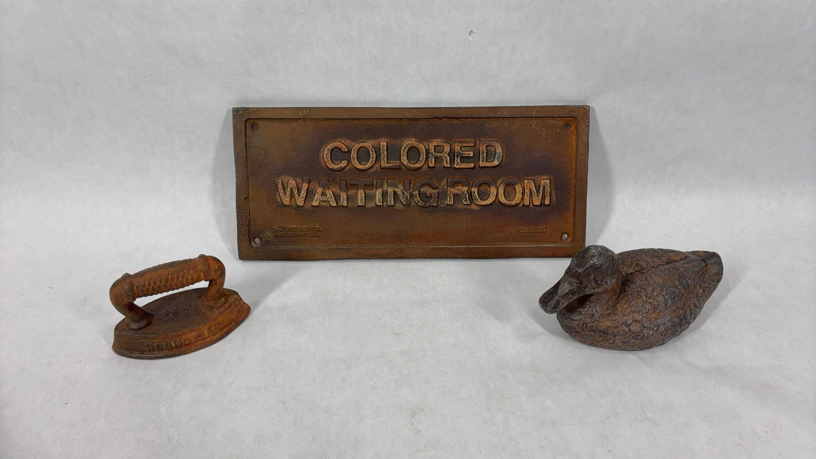 Cast Iron Colored Waiting Room Plaque, Round Oak Sad Iron and CI Duck: This great cast iron lot includes a round oak stoves sad iron collectible 3.5 in w. a cast iron duck 6.5 in l and a cast iron Alans Sign co. Colored Waiting Room plaque dated 1927 unsure of authentici