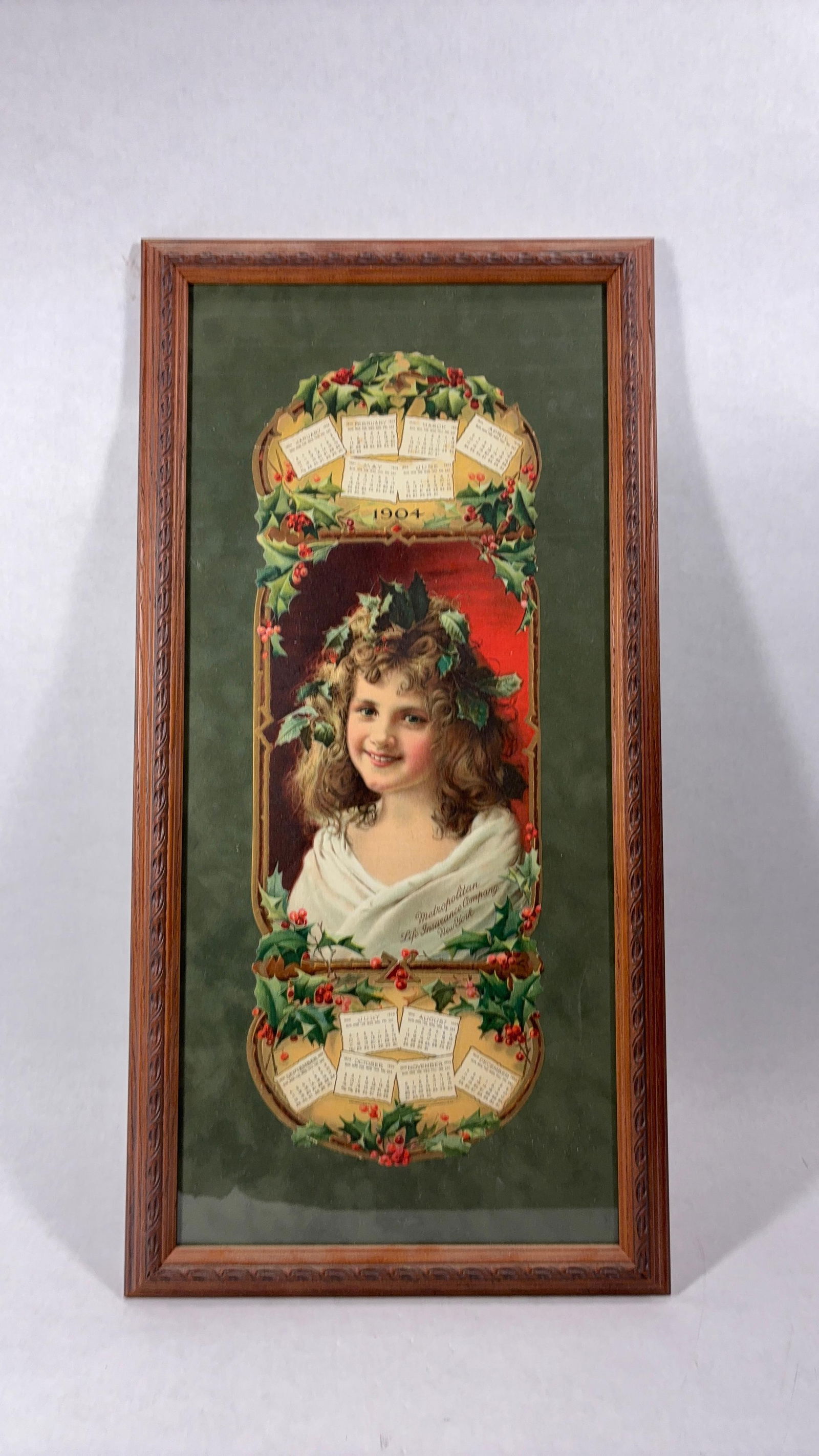 1904 Framed Holly Berry Advertising Calendar: Metropolitan Life Insurance Co. New York American Lithograph co. Excellent color with a Christmas like style. Frame is oak, 26x13