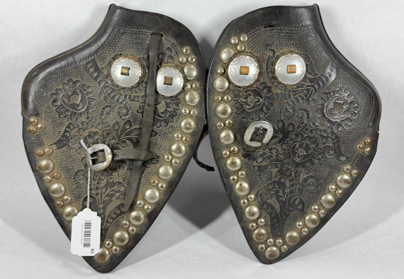 Ornately Decorated Parade Saddle Stirrup Covers: Black engraved leather with silver toned embellishments and buttons. Each is in good condition with dust from age. Leather is pliable. 16x11.5