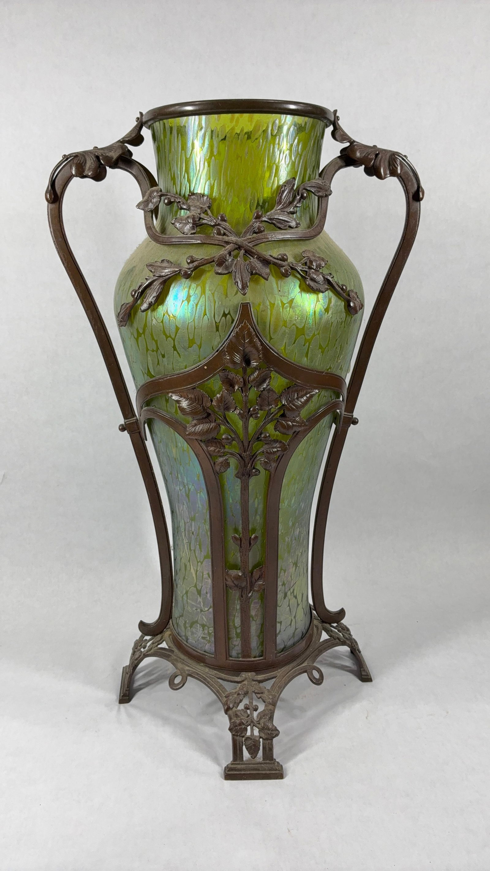 Loetz Bronze Mounted Art Nouveau Vase: From the Bohemian manf Loetz Witwe, featuring an iridescent hand blown glass vase with bronze framing. Ca. 1890-1920s. Vase does show some hairline cracking on lower half but holds together nicely