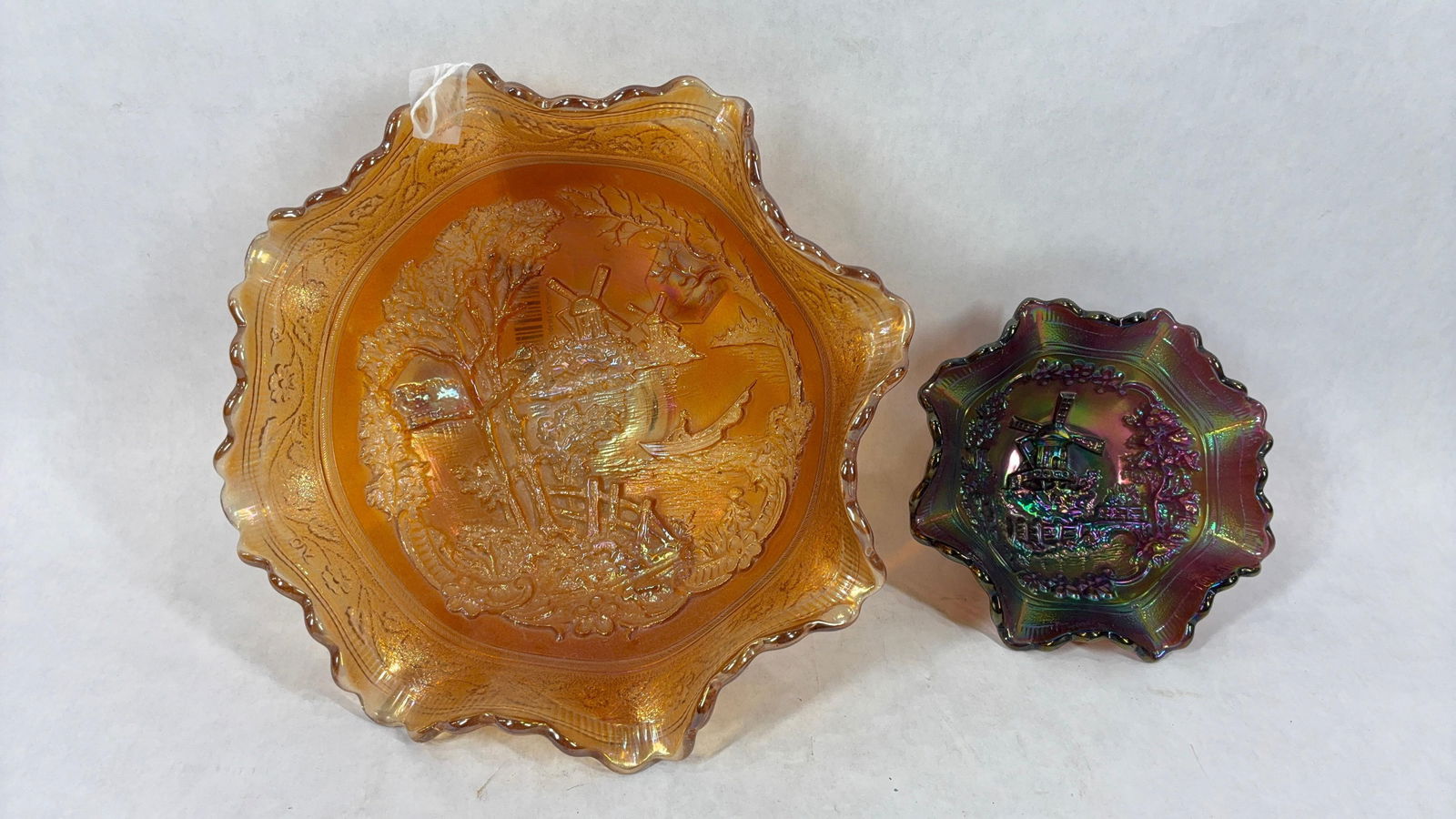 Imperial Glass Windmill Double Dutch Glass Bowls: Marigold and amethyst. Early 1900s, each with ruffled edge and embossed scene. Both are excellent condition with no damage. 5.5 and 9 inches in diameter