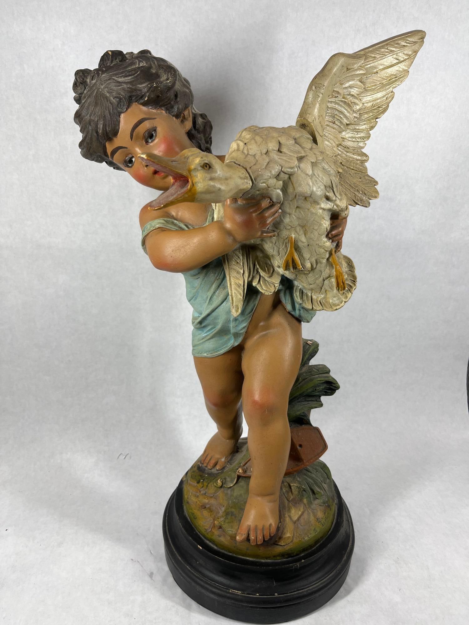1930s Large English Child With Goose Statue: Ceramic figure with removable wing and head for easy storage or transport. Standing on a bese the child shows a blue draped garment and no shoes. 23 inches tall. Several small areas of paint chip but