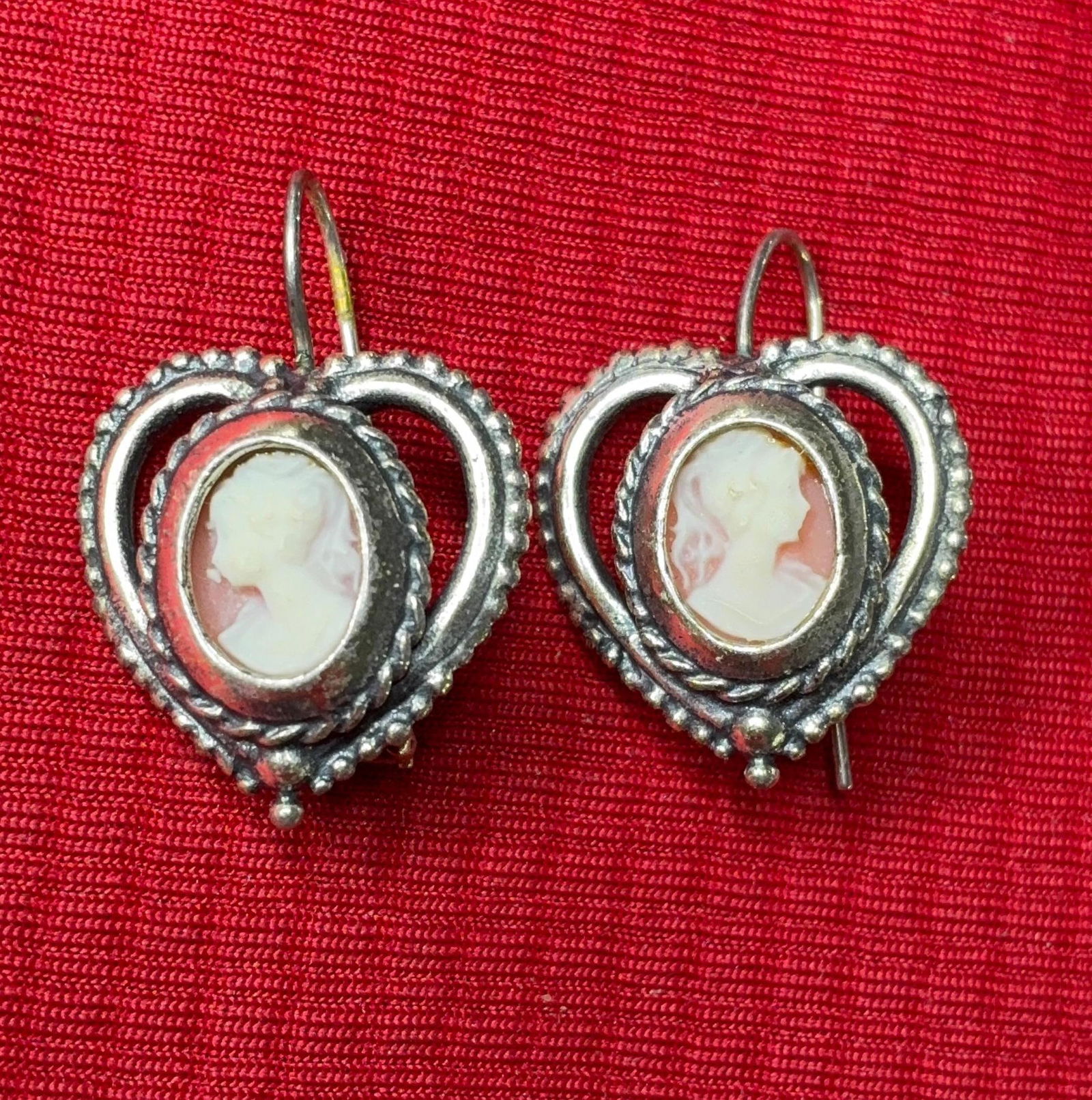 Carved Cameo Sterling Earrings: Heart shaped sterling frames with a twisted rope design, encases a small carved cameo portrait. Marked sterling.