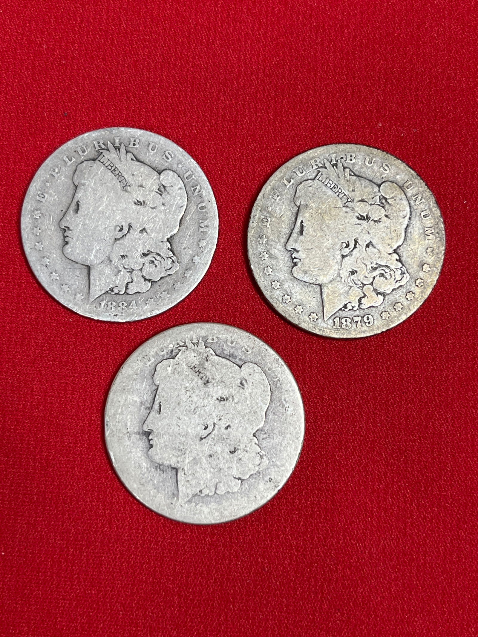 3 Morgan Silver Dollars: 1879, 1884, and one unreadable date. All are worn