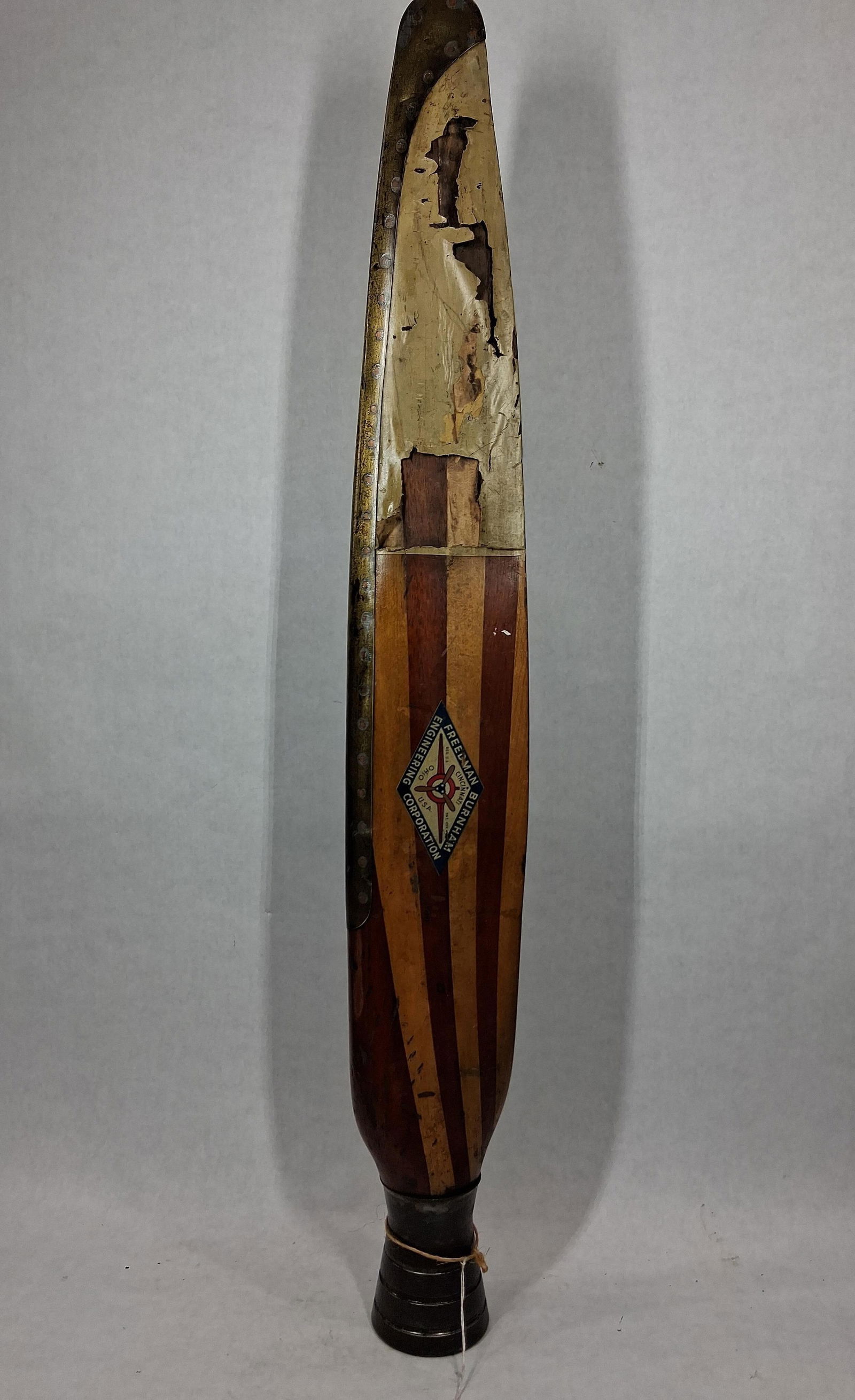 Freedman Burnham Wooden Plane Propeller: A half prop with center section perfect for display. Striped wood with a brass edge. Cincinnati Ohio. 38 inches tall