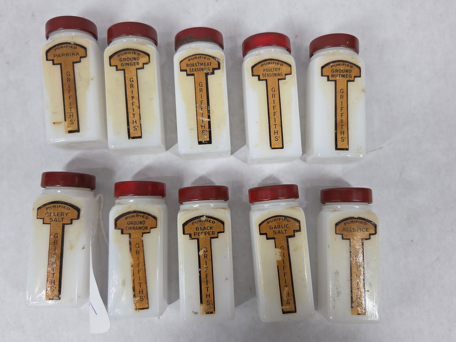 Griffiths Milk Glass Spice Jars: 10 jars with tin lids. Each a different spice. Each is 3.5 inches tall.