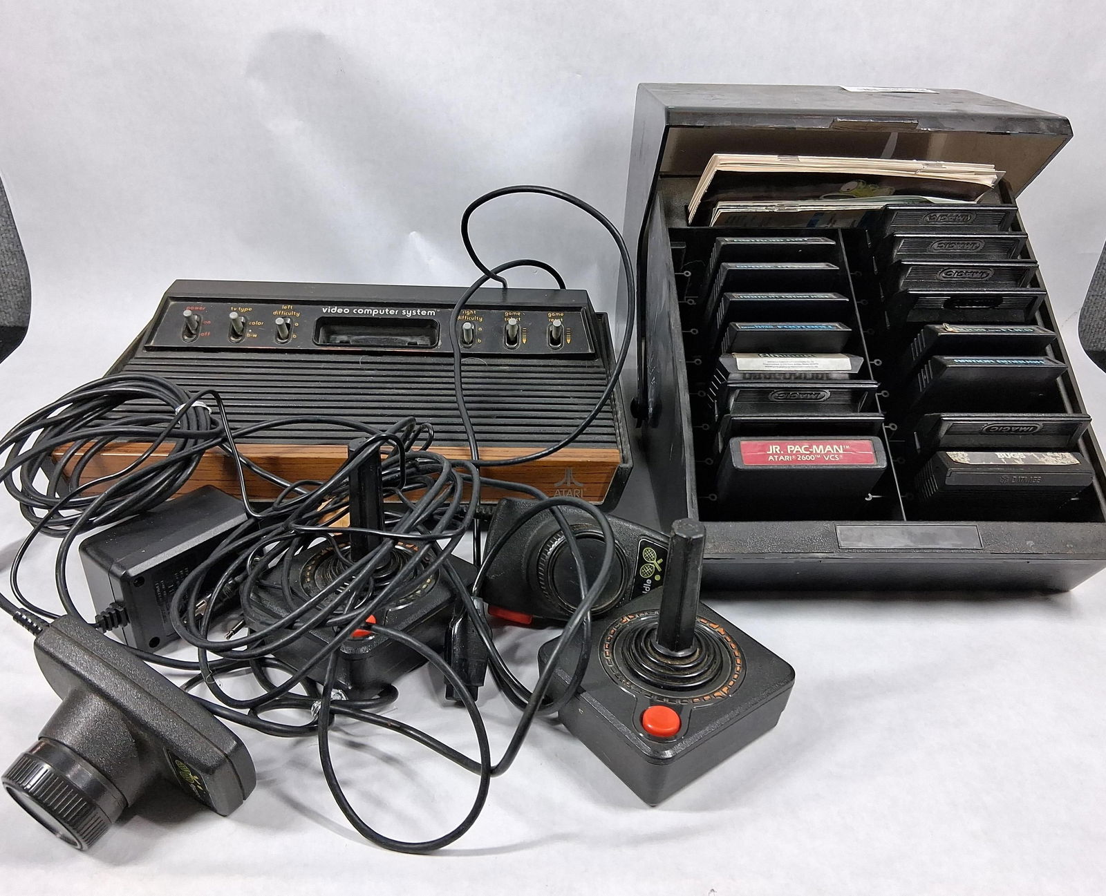 Atari Video Computer System w/ Console, Controllers, Paddles and Game Cartridges w/ Case: This great vintage game console system is in good overall condition appearing to be complete with cords, paddles, joy sticks as well as many game cartridges in storage case inc. bugs, jr. pac man, spa