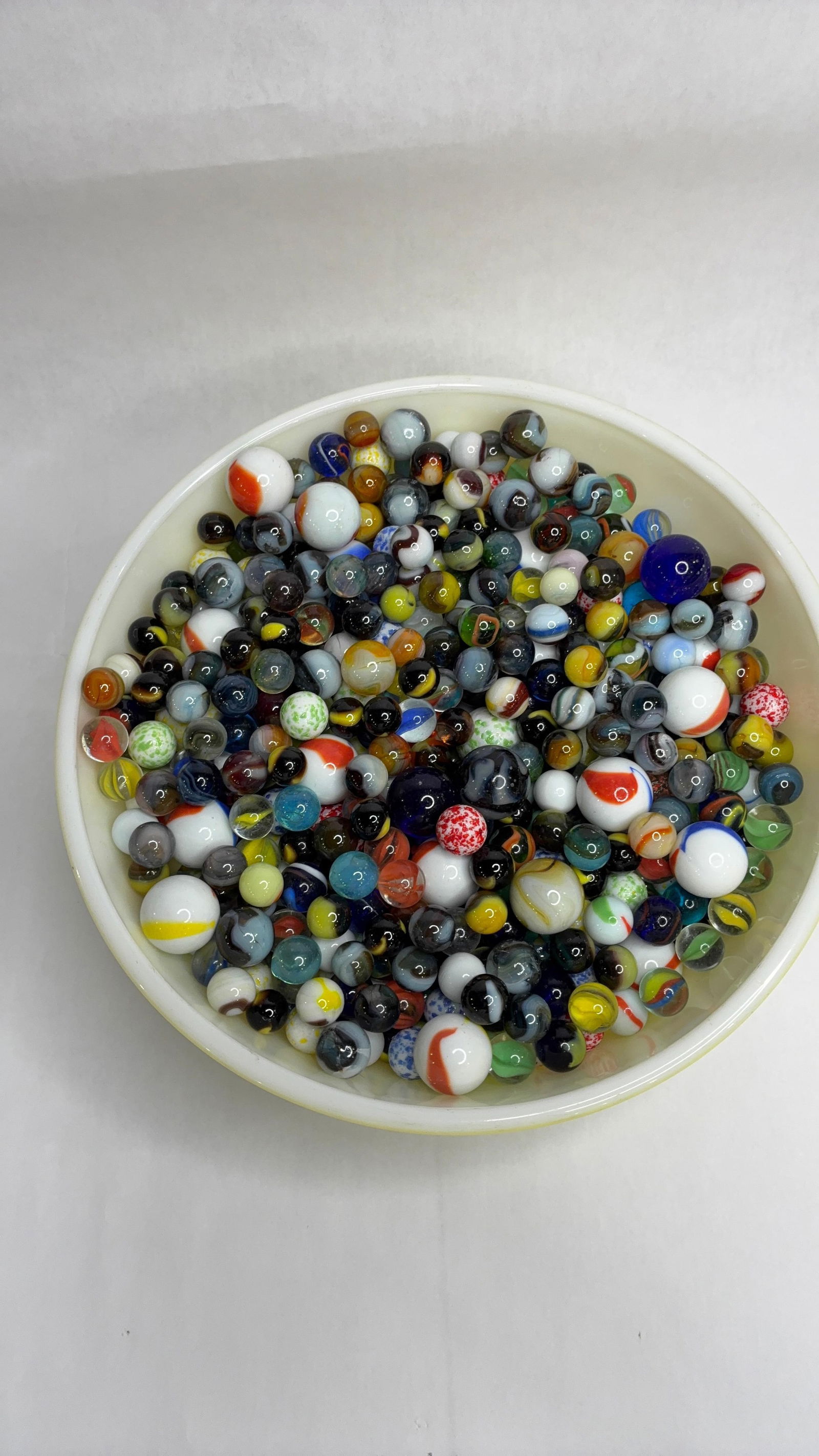 Pyrex Bowl Filled with Early Marbles: Some are uranium glowing marbles. Bowl is in great condition.
