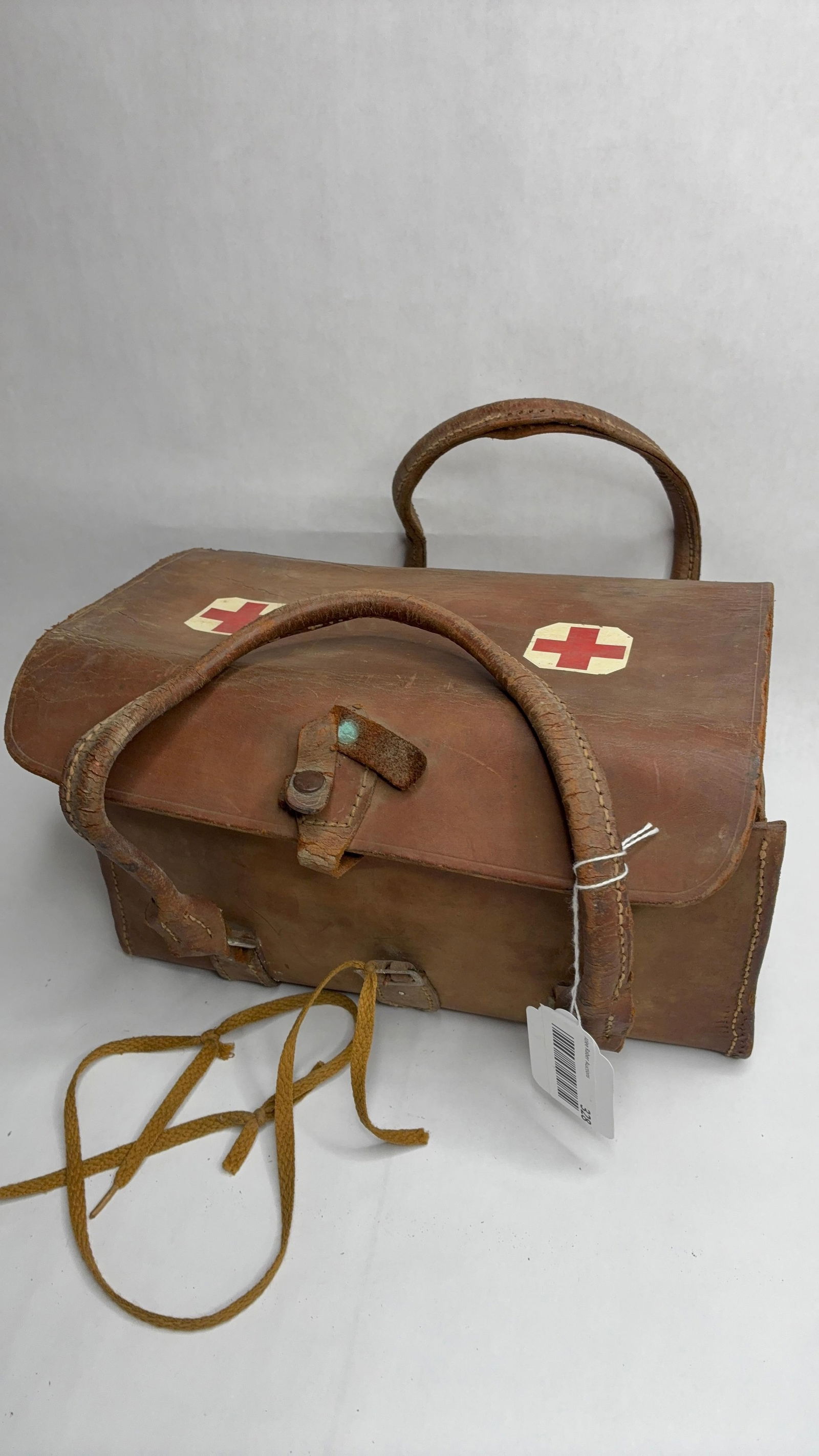 Early Military Red Cross First Aid Bag & Contents: Leather bag with folding flap sides. Includes tin medical instruments pan, blood pressure cuff, and more.