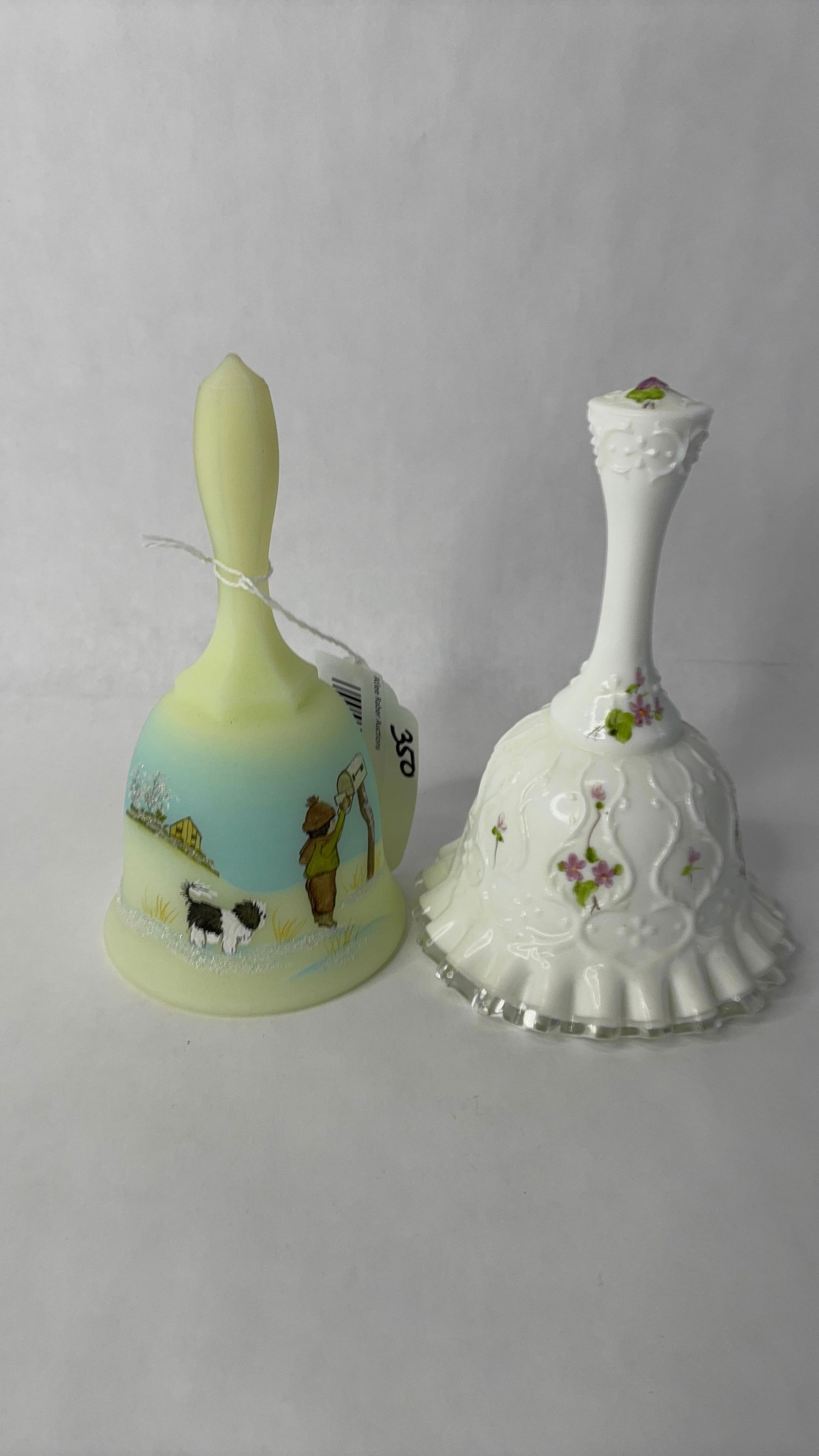 2 Fenton hand painted bells: One uranium bell with boy/dog at mail box and floral bell both hand painted and signed