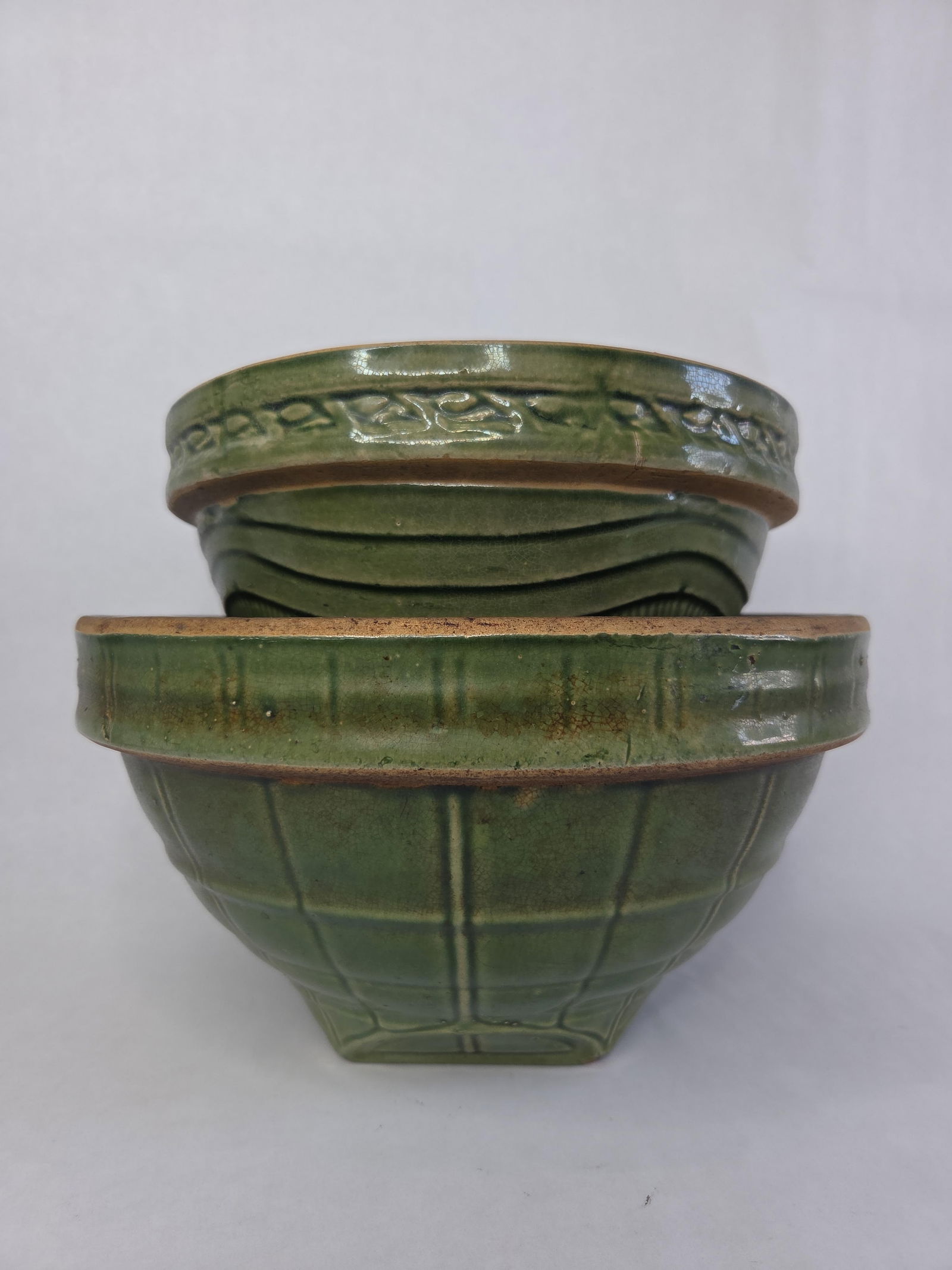 2 olive green McCoy window pane mixing bowls: Largest bowl has a hairline cracked and largest bowl is 11 inches in diameter. Small bowl is free of chips or cracks.