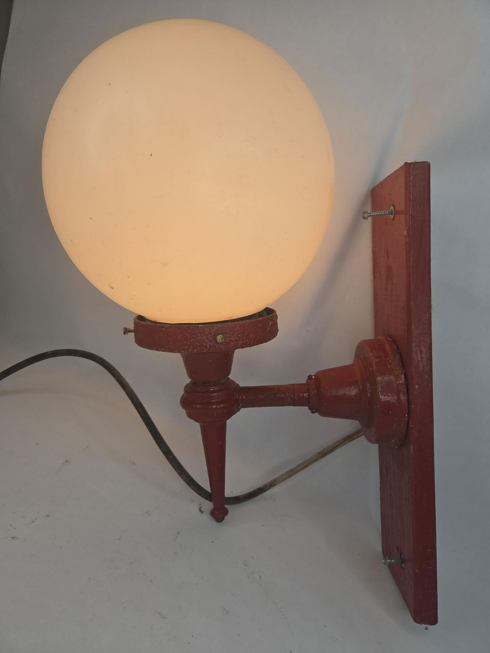 Red painted cast iron street lamp with plastic globe mounted on wood (1 of 4)