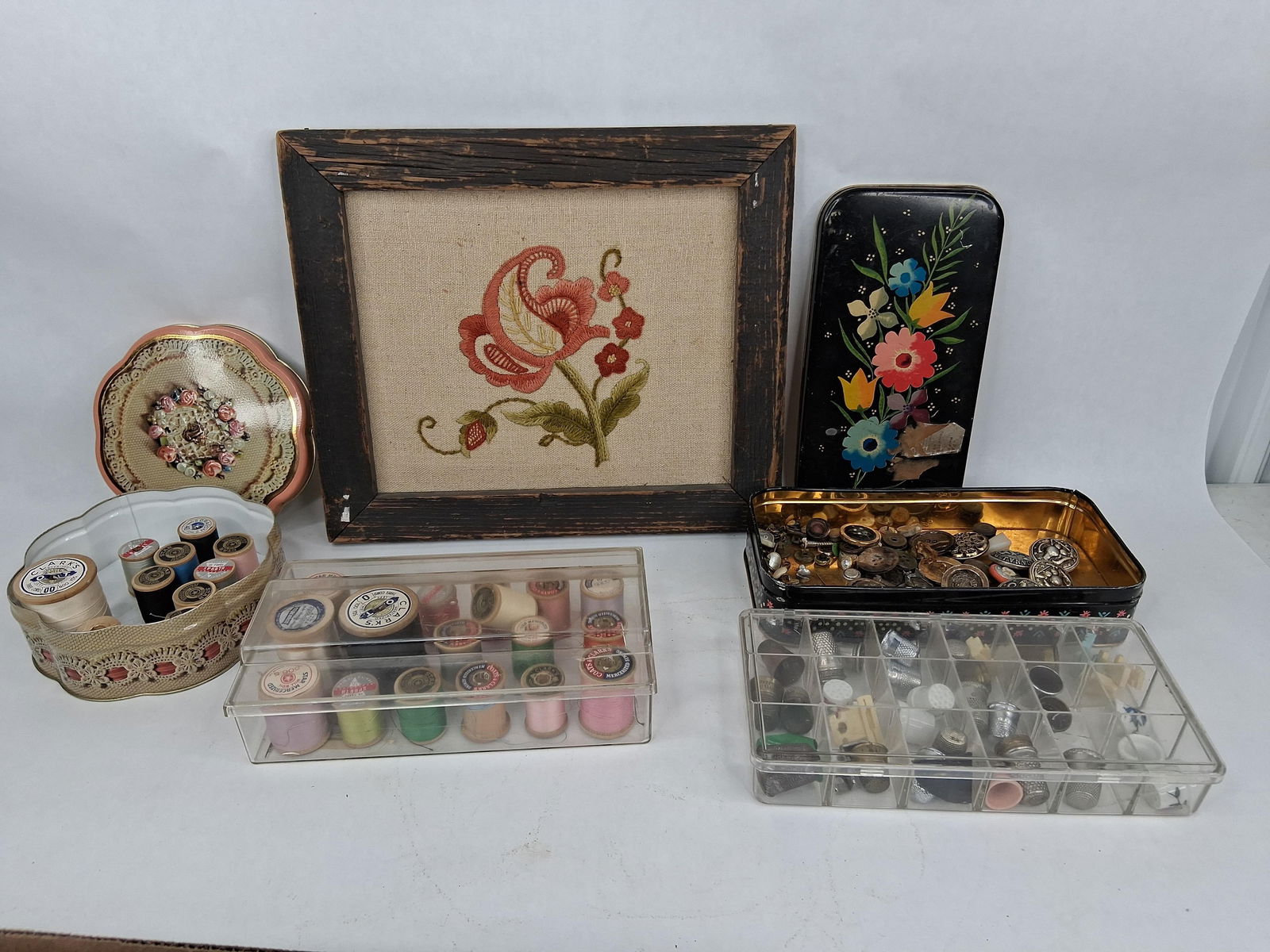 Wooden spools with tread ,thimbles, buttons ,and framed embroidery: frame is 11.5x 10